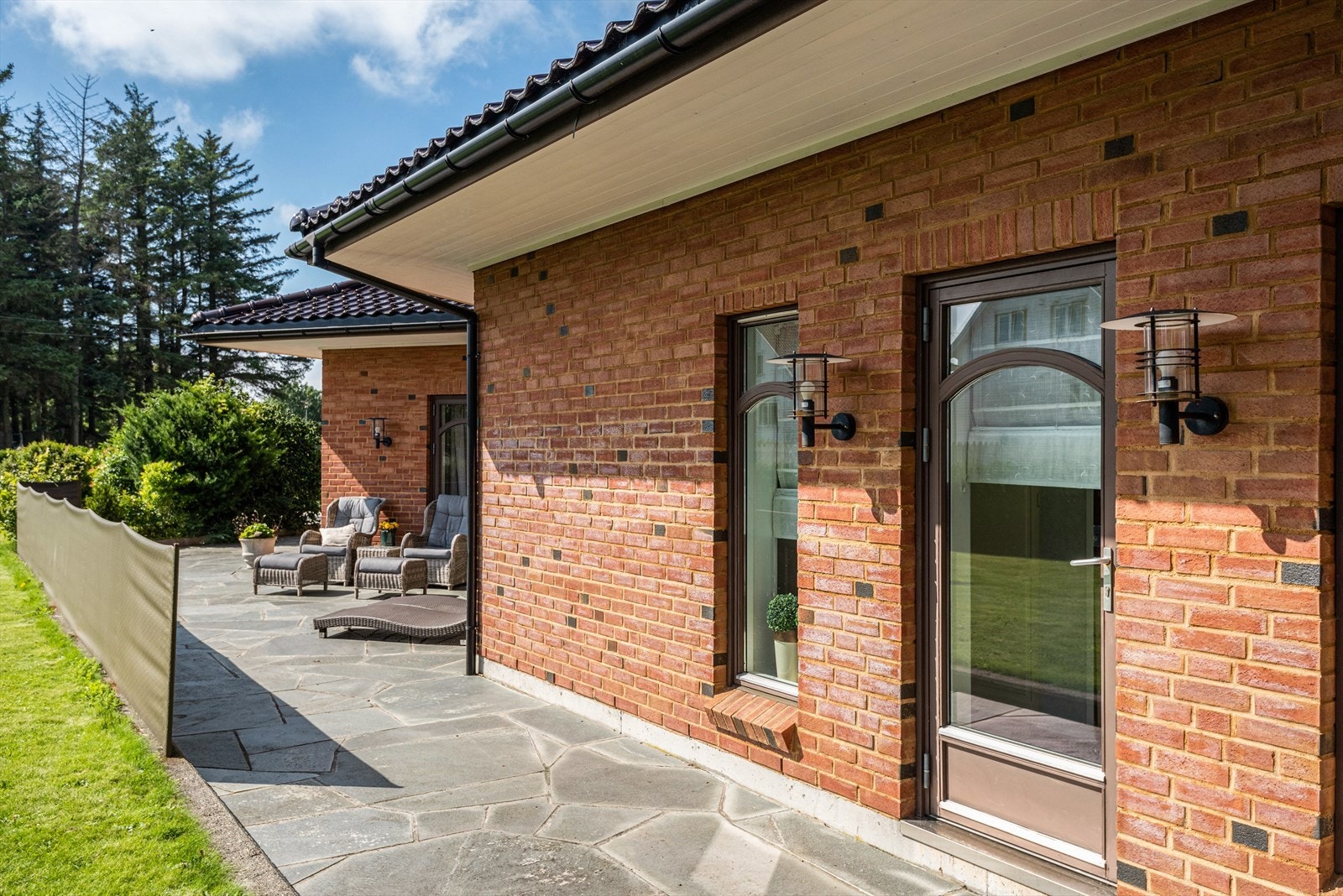 Store deler av eiendommen er omkranset av hekk. Tomta er raust beplantet med frodige prydbusker og stauder. Galleribilde