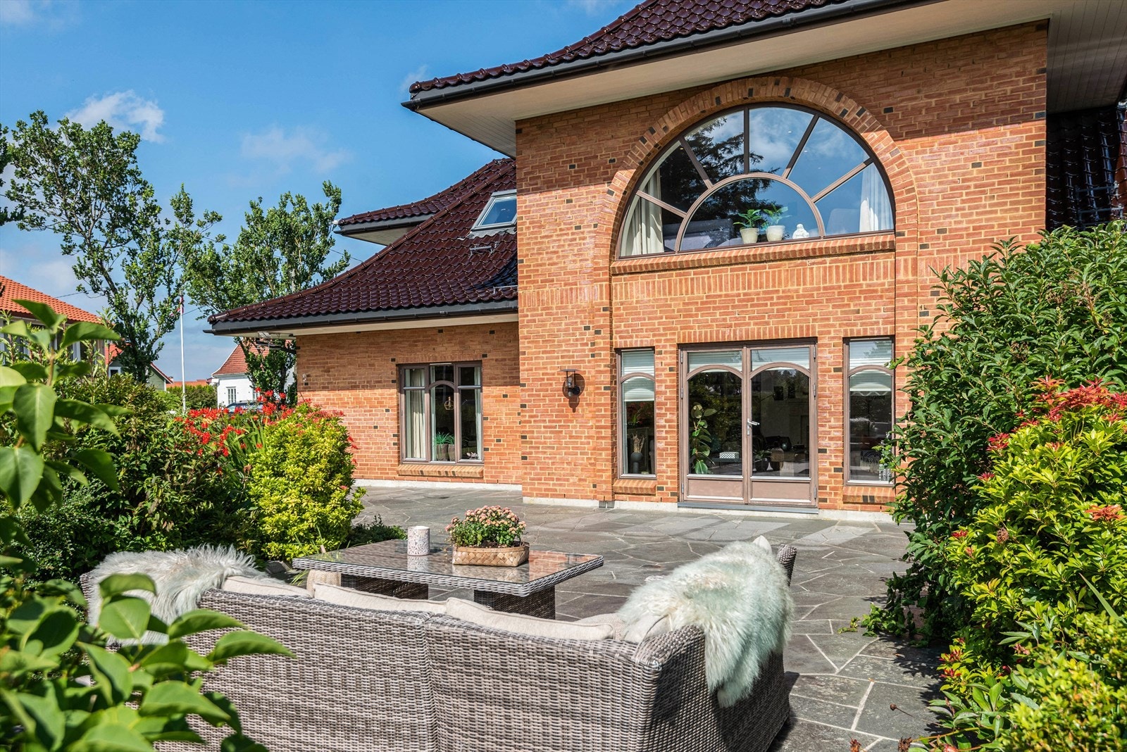 Eiendommen har store, solrike uteområder, med skiferterrasse, flott beplantning og plen. Galleribilde