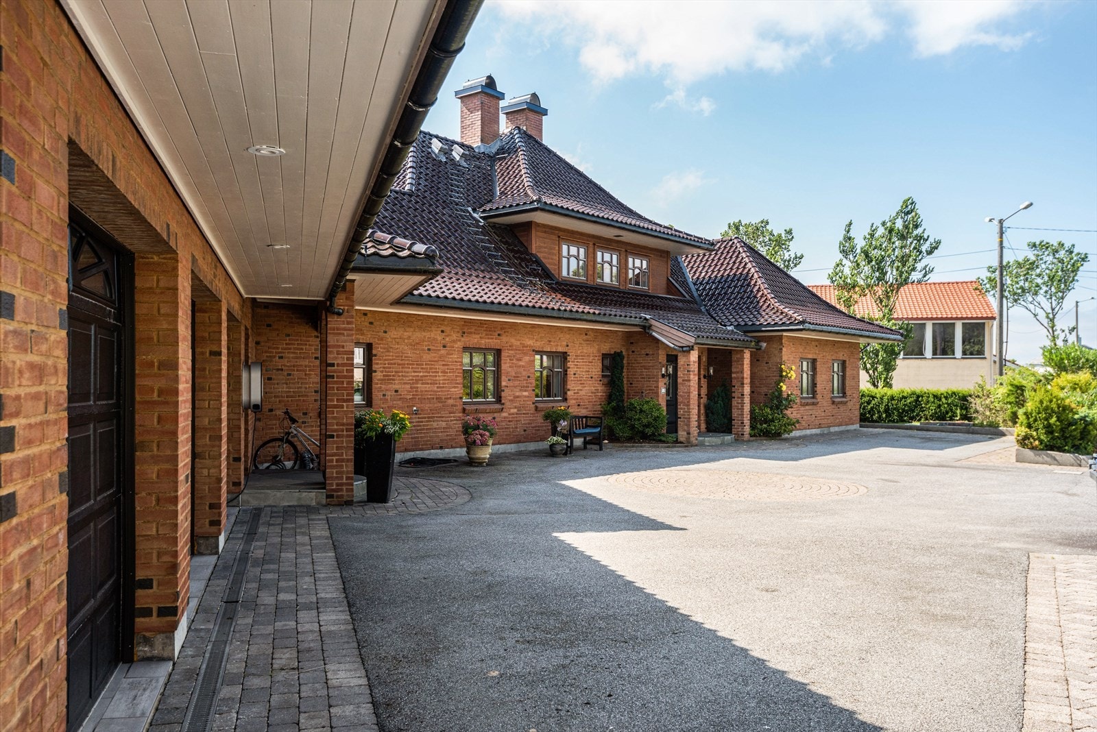 Rikelig med parkeringsmuligheter, både i trippel garasje og stort gårdsrom med asfalt og belegningsstein. Galleribilde