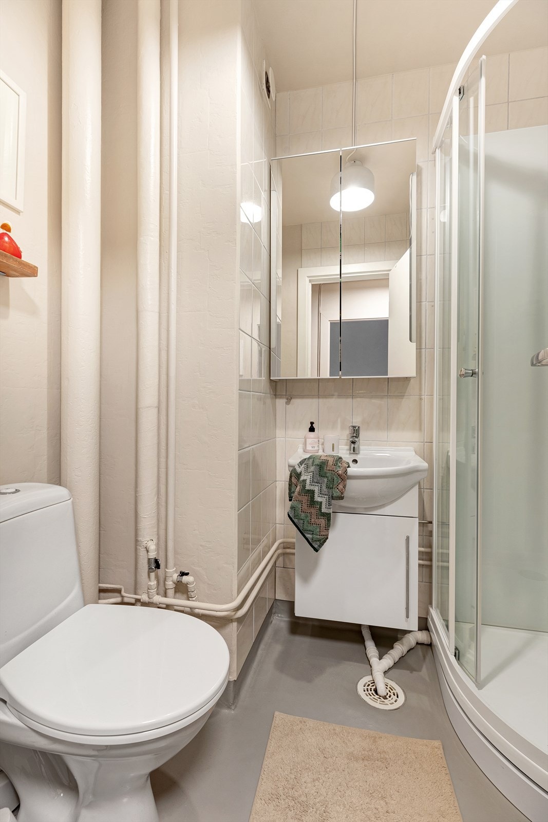 Baderomsinnredningen bestående av innredning med vask, dusjkabinett, wc og opplegg for vaskemaskin. Galleribilde