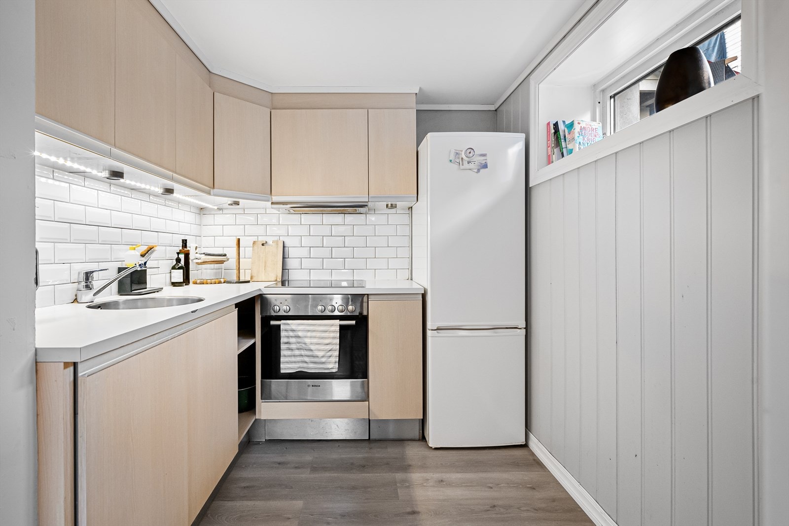 Kjøkkeninnredningen har glatte finérfronter og laminert benkeplate. Galleribilde
