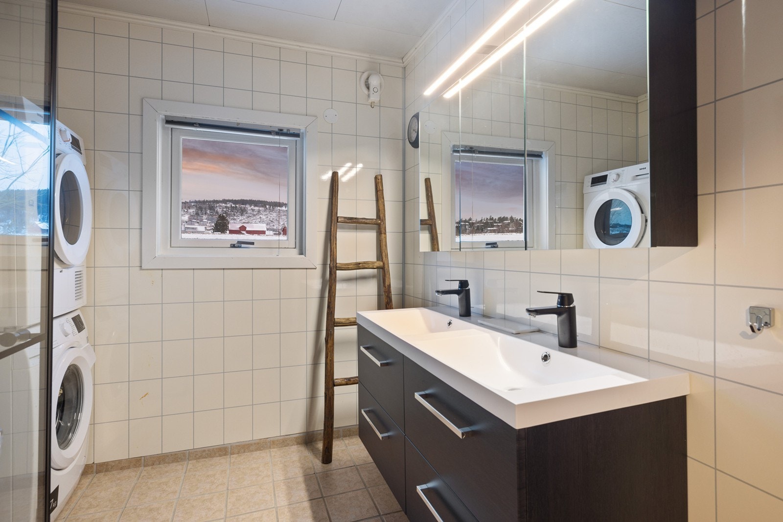 Innredningen består av et underskap/overskap, dobbel servant, speil og lys, stikk og en dusjsone. Det er opplegg for vaskemaskin/tørketrommel. Galleribilde