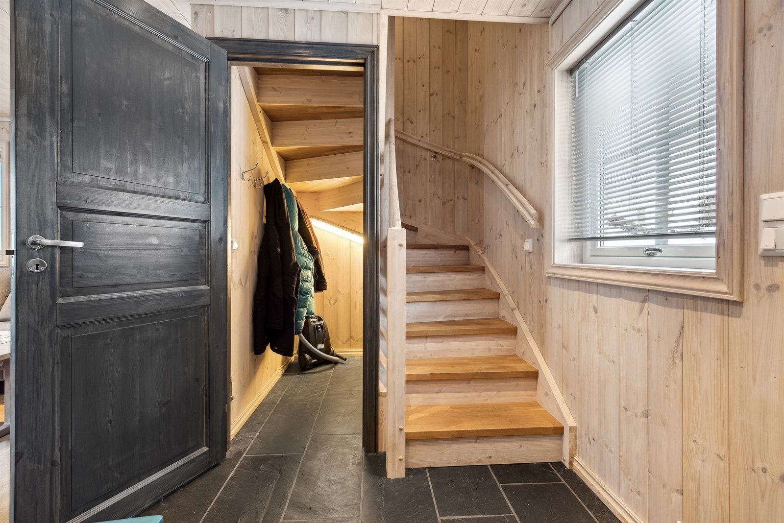 Under trappen til andre etasje har god lagringsplass. Her er det varmekabler i gulv som er er perfekt for jakker og sko som trenger tørk. Galleribilde