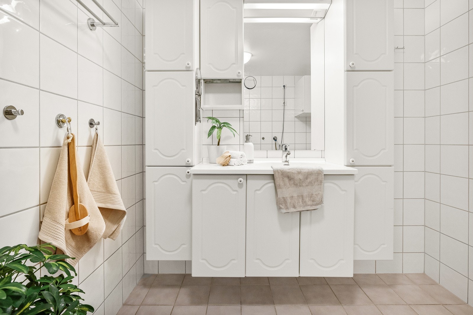 Badet er innredet med vegghengt servantinnredning, speil med overlys og stikkontakt, vegghengt møblement ved speil, vegghengt baderomsmøbel med dør, dusjkabinett med dusjarmatur, opplegg for vaskemaskin og gulvstående toalett. Galleribilde