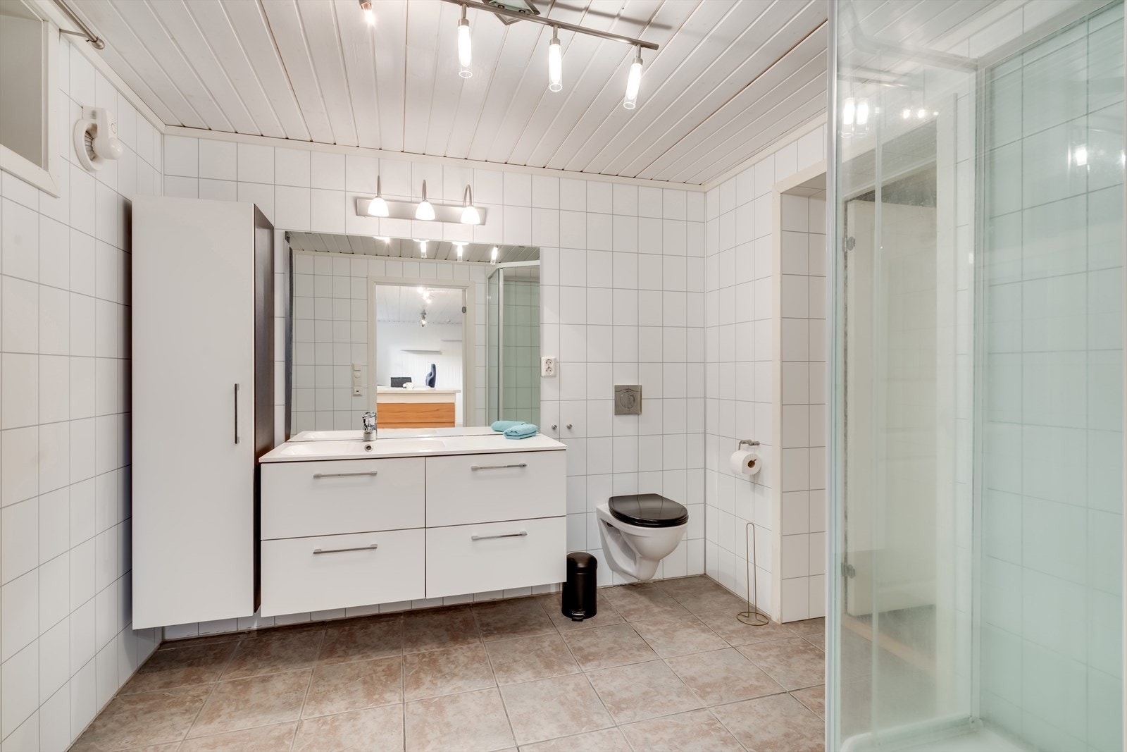 Badet har flislagt gulv med elektrisk varmekabler og baderomsplater. Her er også opplegg for vaskemaskin. Galleribilde