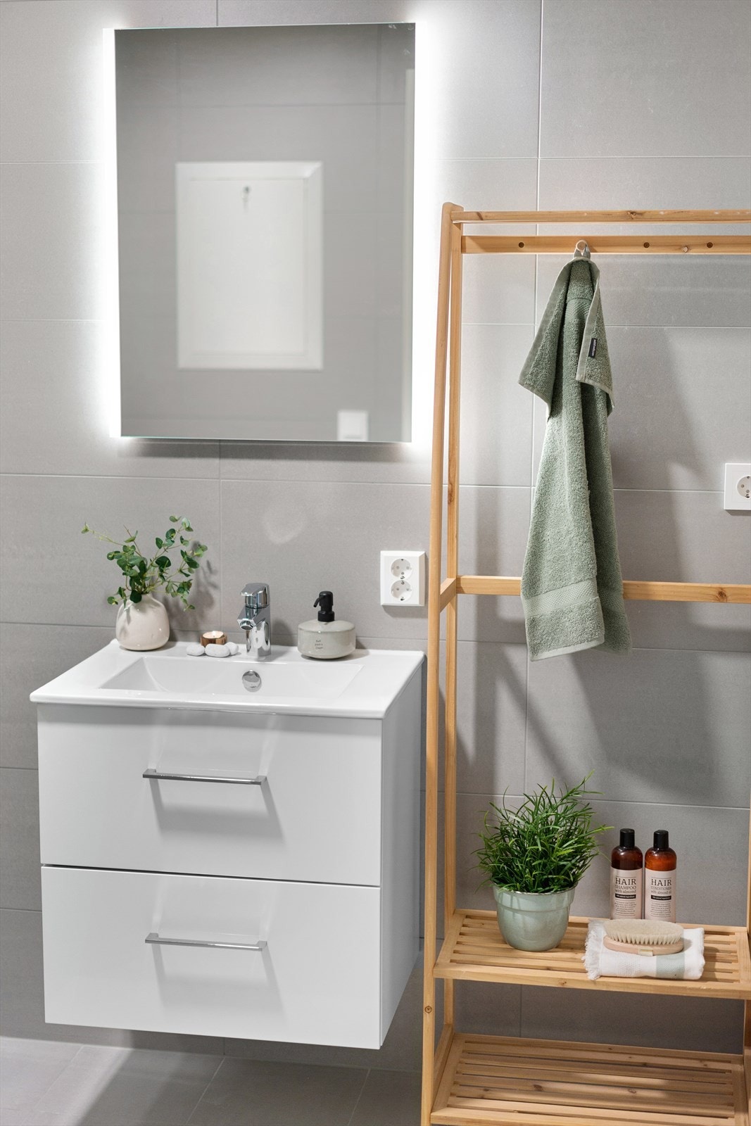 Badet er innredet med heldekkende servant på skuffeseksjon, speil med integrert belysning, vegghengt toalett og dusjhjørne. Galleribilde