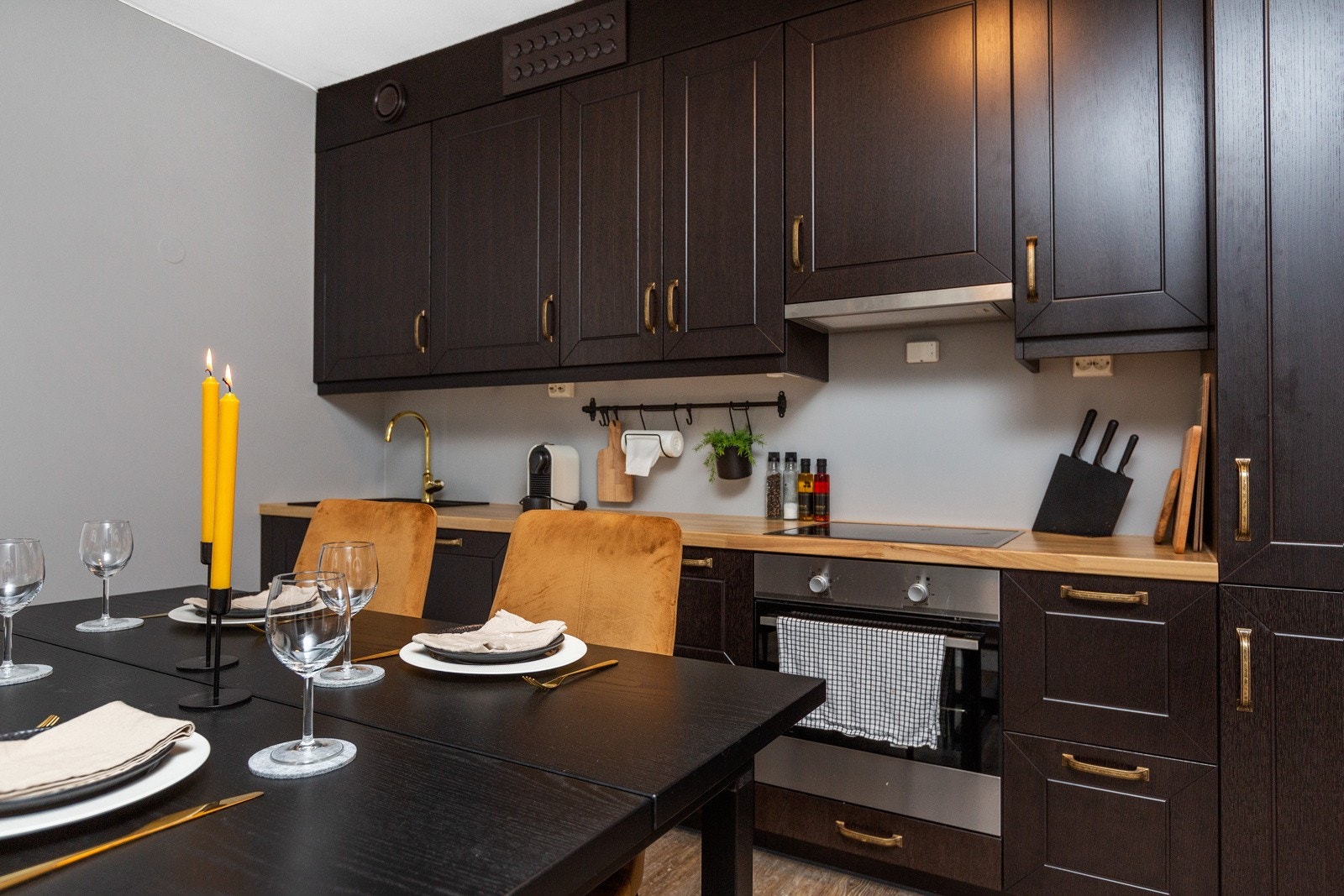 Kjøkkenet har integrerte hvitevarer; keramisk platetopp, stekeovn, oppvaskmaskin, kjøl-/fryseskap og avtrekksvifte med kullfilter over kokeplate Galleribilde