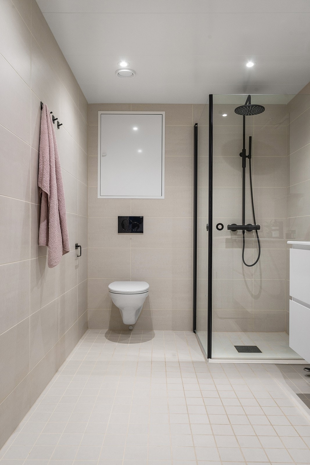 Lekkert baderom med varme i gulv og downlights i himling - Investert i armatur i dusj og på servant, dusjvegger og trykkknapp til toalettet Galleribilde