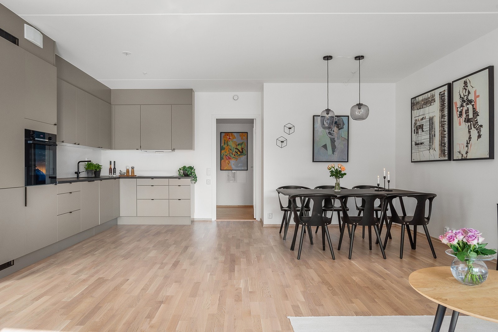 Åpen stue/kjøkken løsning med plass til stort spisebord tilknyttet kjøkkenet Galleribilde