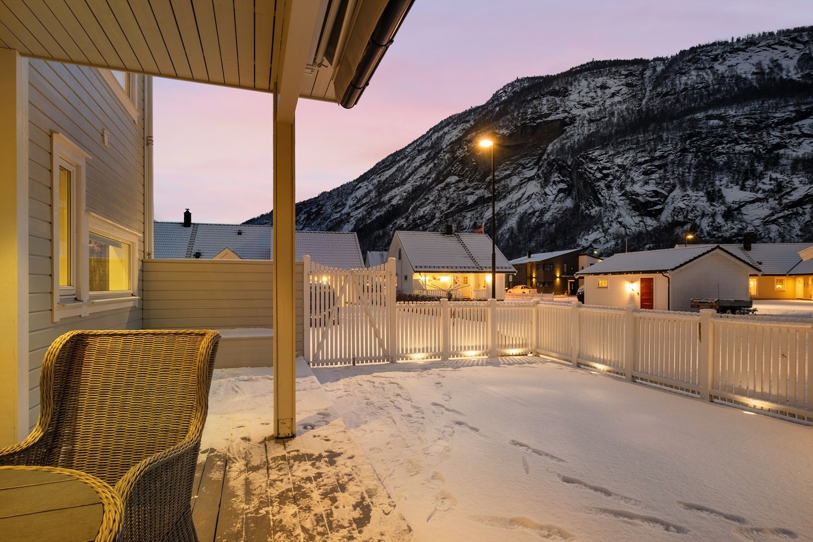 Flat tomt med asfaltert tun og gangbaner, og stor terrasse i hagen. Galleribilde