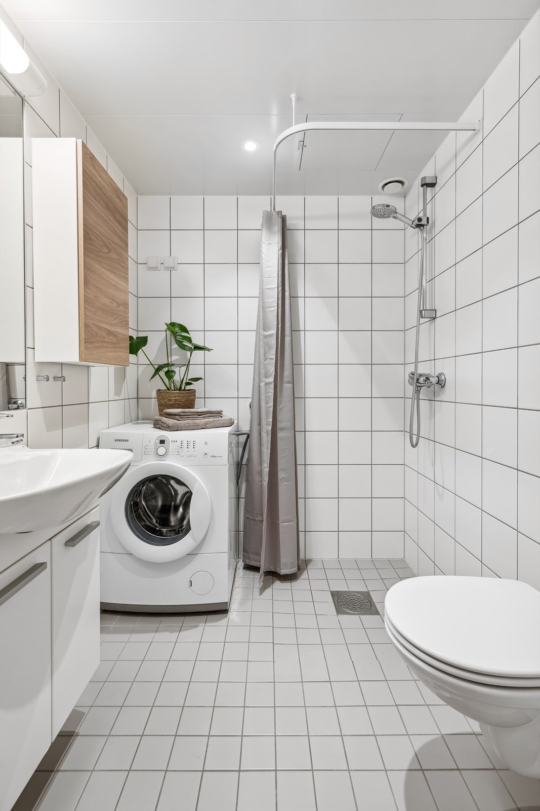 Flislagt baderom med elektriske varmekabler i gulv og lakkerte stålplater med downlights i himling. Galleribilde