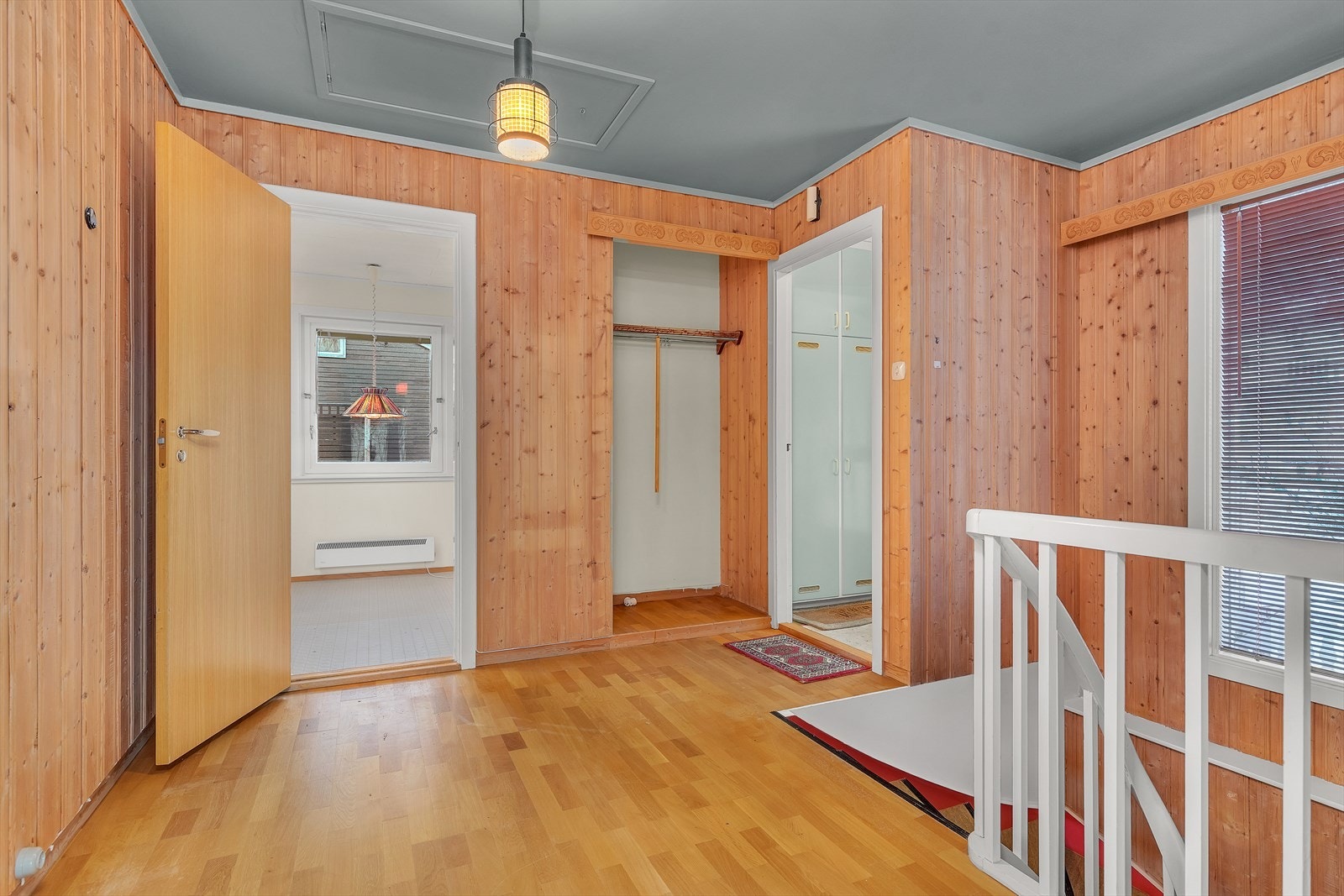 Romslig hall med adkomst til både kjøkken og stue samt trapp til underetasje Galleribilde