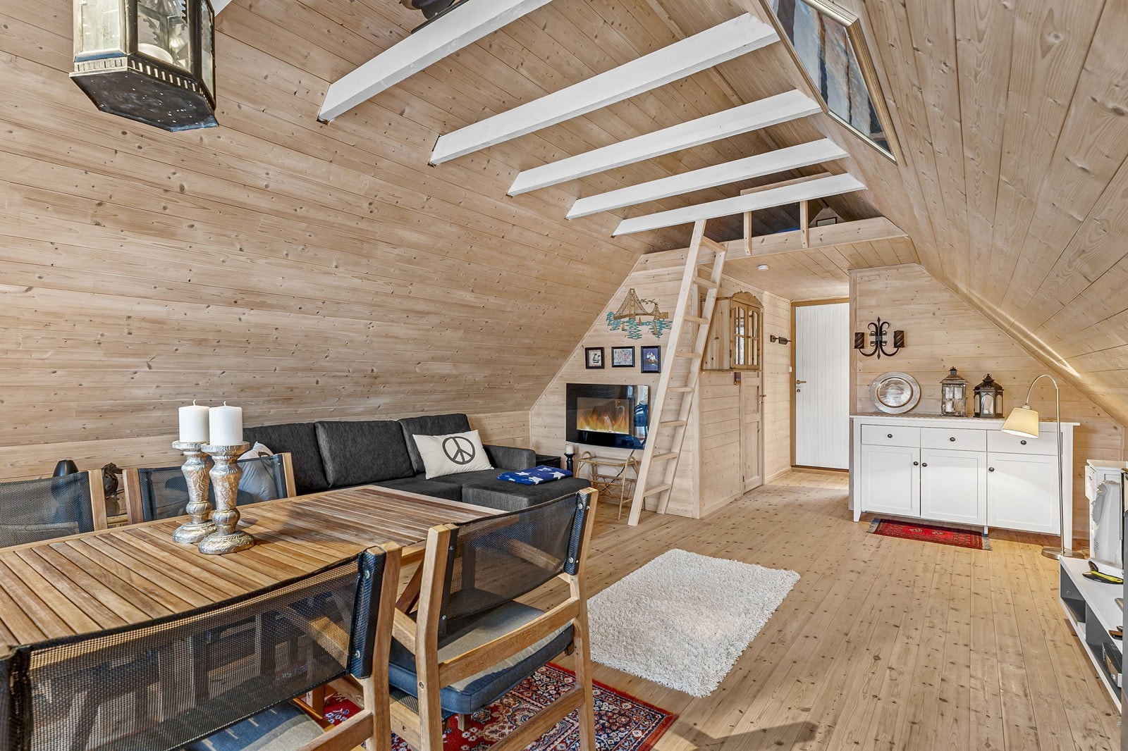 Stuedelen har god takhøyde med synlige takbjelker og trapp opp til hems. Galleribilde