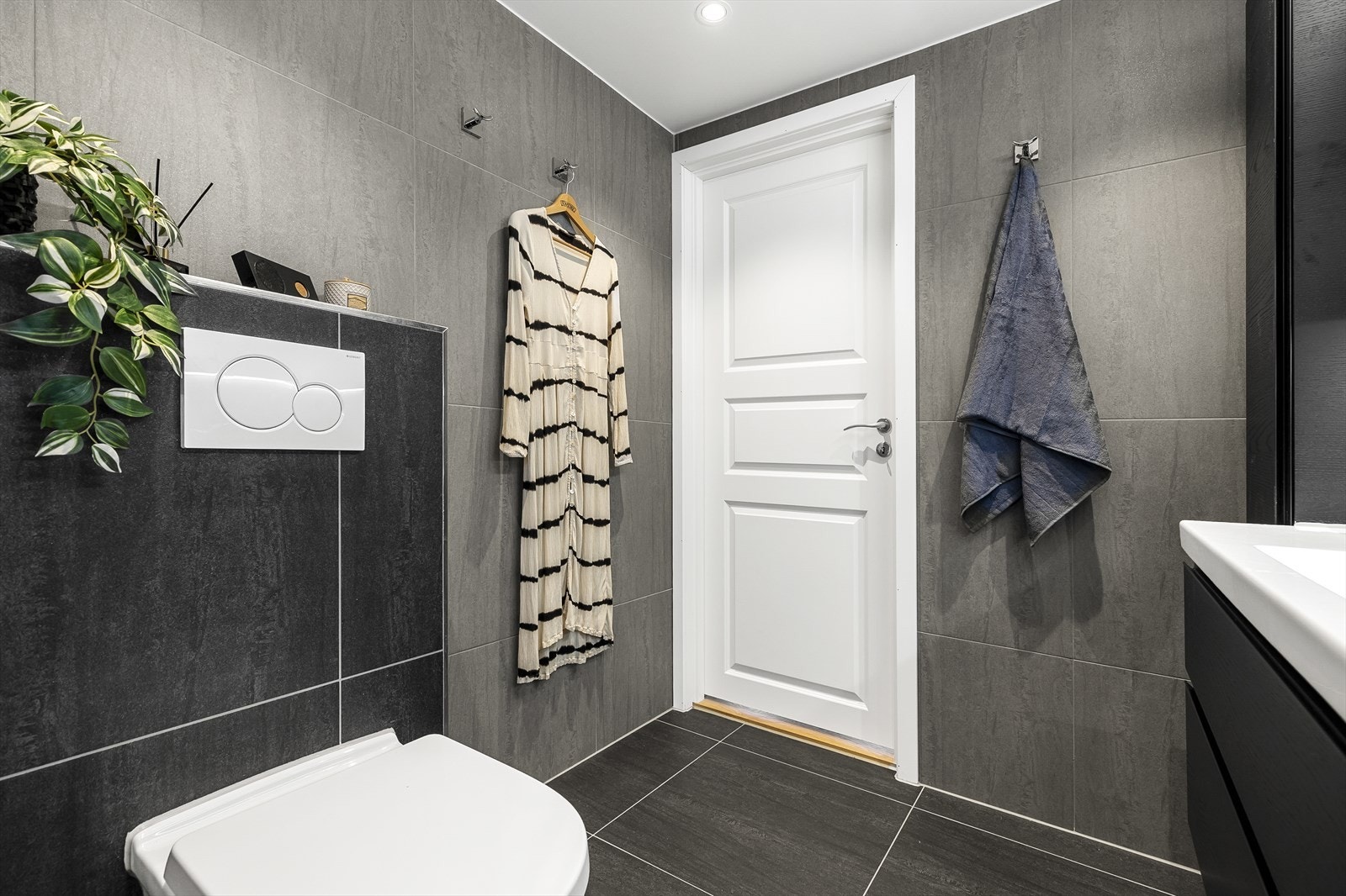 Badet har store og lekre fliser på gulv og vegg, samt malt flate i himling med downlights Galleribilde
