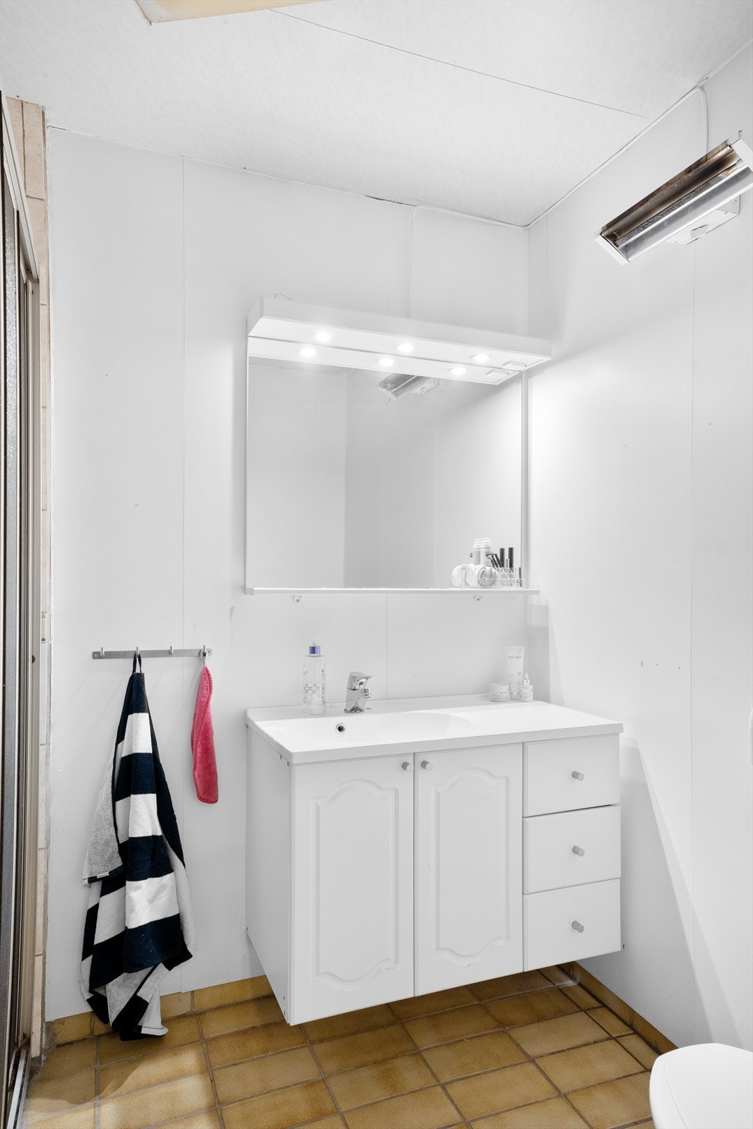 Bad i underetasjen med baderomsplater på veggene som er malt i 2017 Galleribilde