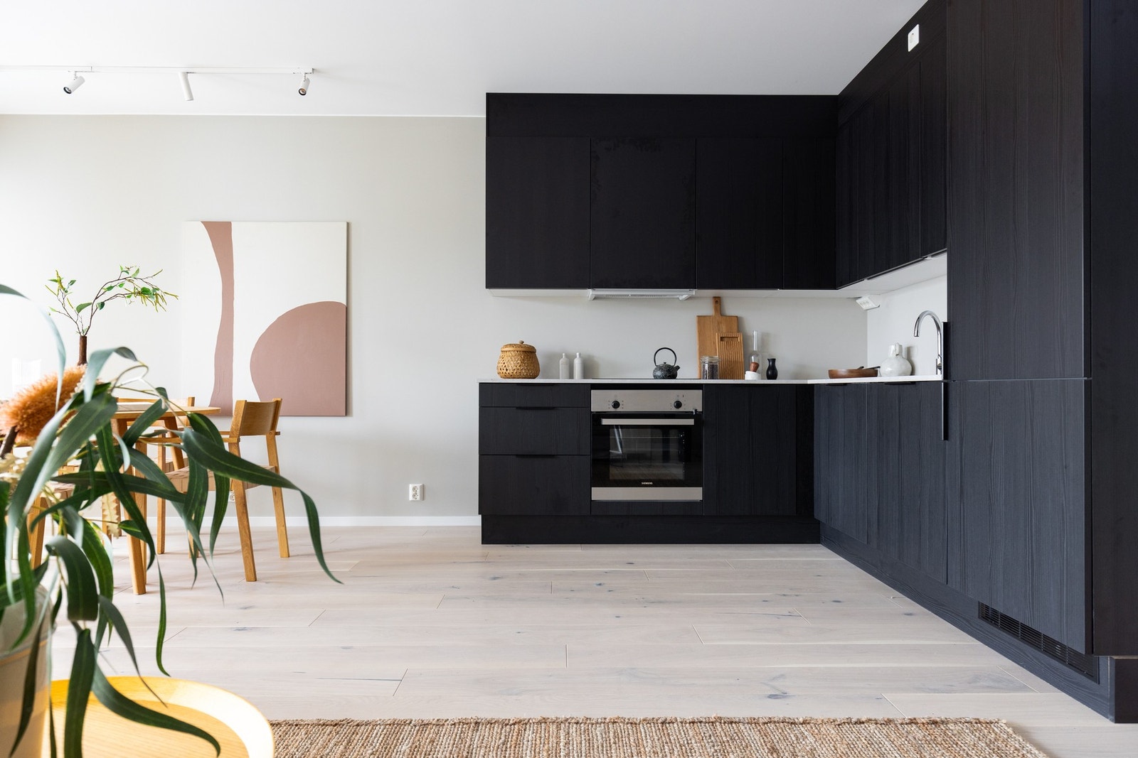 Lekkert HTH-kjøkken i mørk, glatt utførelse med stilig benkeplate, utslagsvask med ett-greps blandebatteri samt stikkontakter og belysning under overskap. Galleribilde