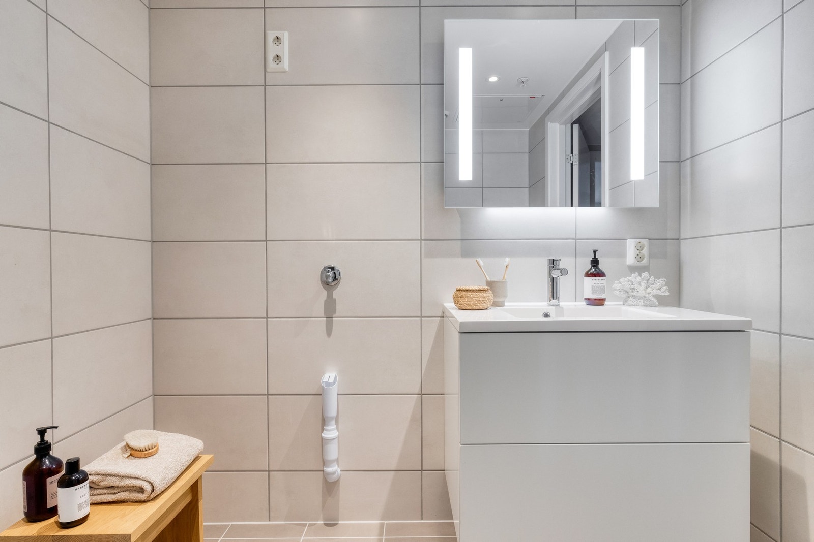 Innredningen består av baderomsmøbel med to skuffer og ovenpåliggende servant, samt speil med lys og stikkontakt. Galleribilde