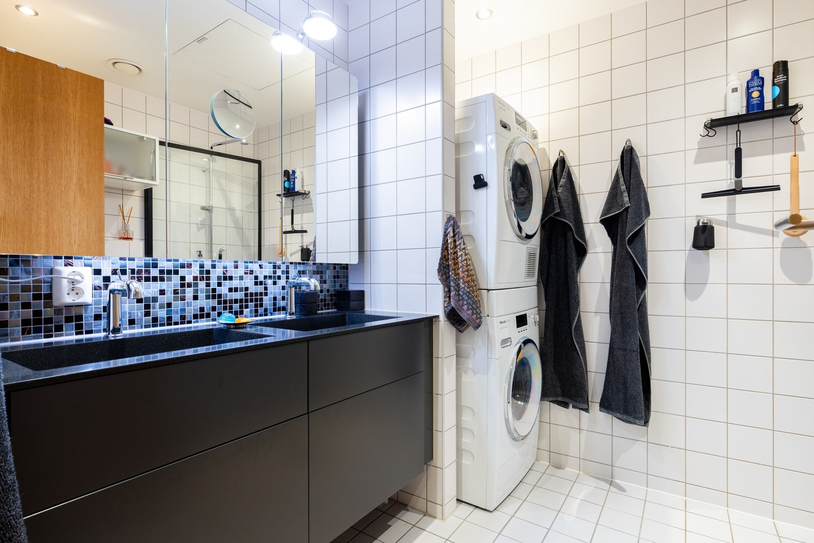 Videre har leiligheten et flislagt bad. Det er opplegg og plass for både oppvaskmaskin og tørketrommel. Galleribilde