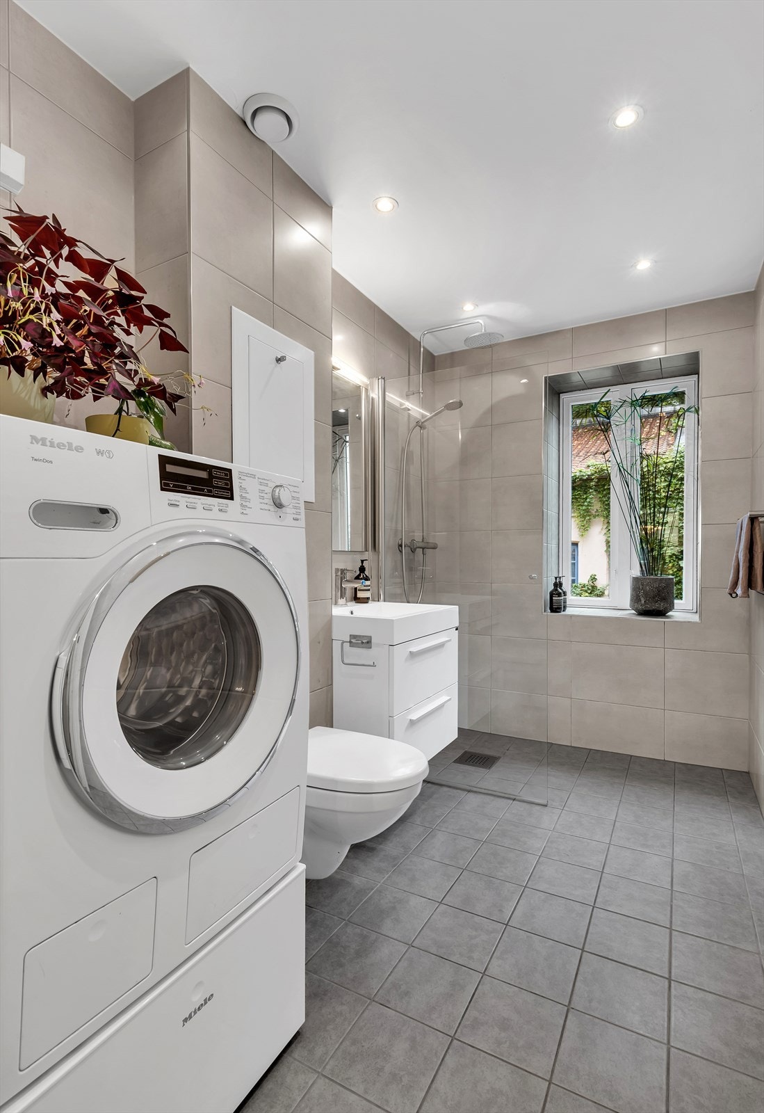 Flislagt baderom med varme i gulv og innfelte lys i himling. Galleribilde