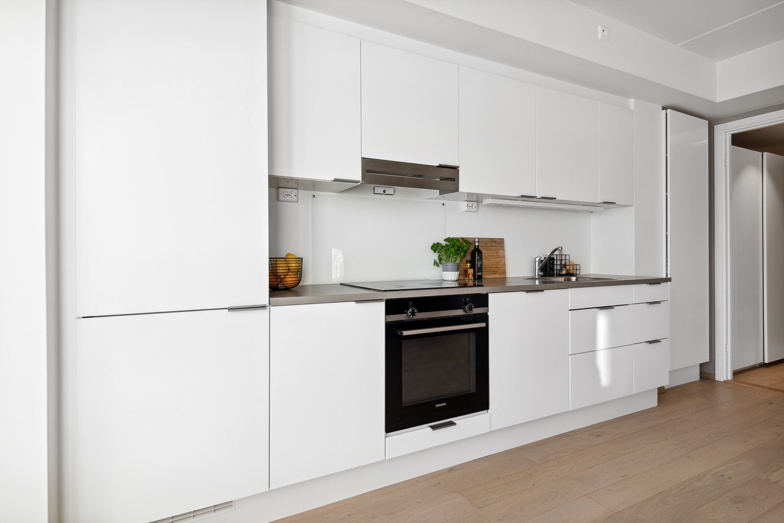 Innredningen har hvite glatte fronter, benkeplaten er i laminat. Galleribilde