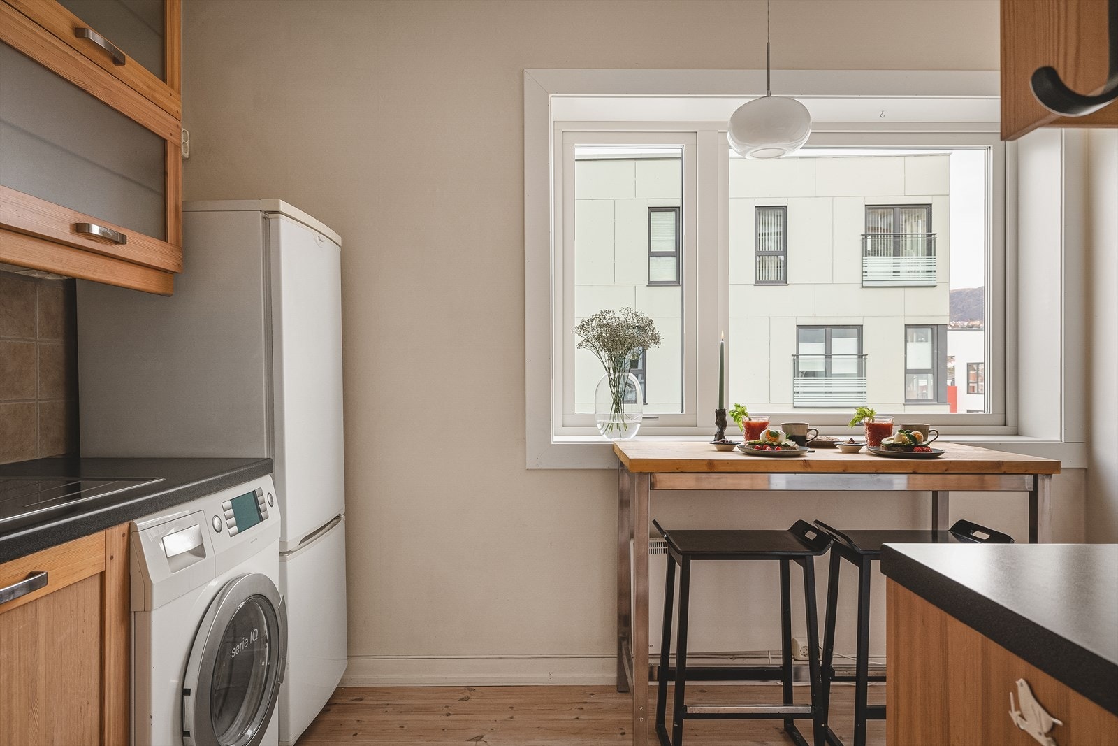 Kjøkkeninnredning med profilerte fronter, enkelte overskap med glassfronter og laminat benkeplate. Galleribilde