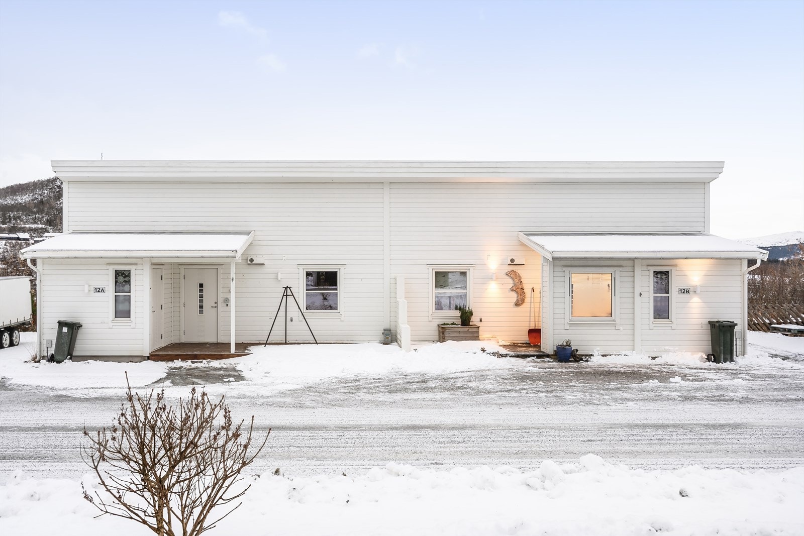 Pen halvpart av vertikaldelt tomannsbolig, oppført i 2014. Overbygd inngangsparti på ca. 5 m² i vest med platting på ca. 14 m² og inngang til sportsbod på ca. 5 m². Galleribilde