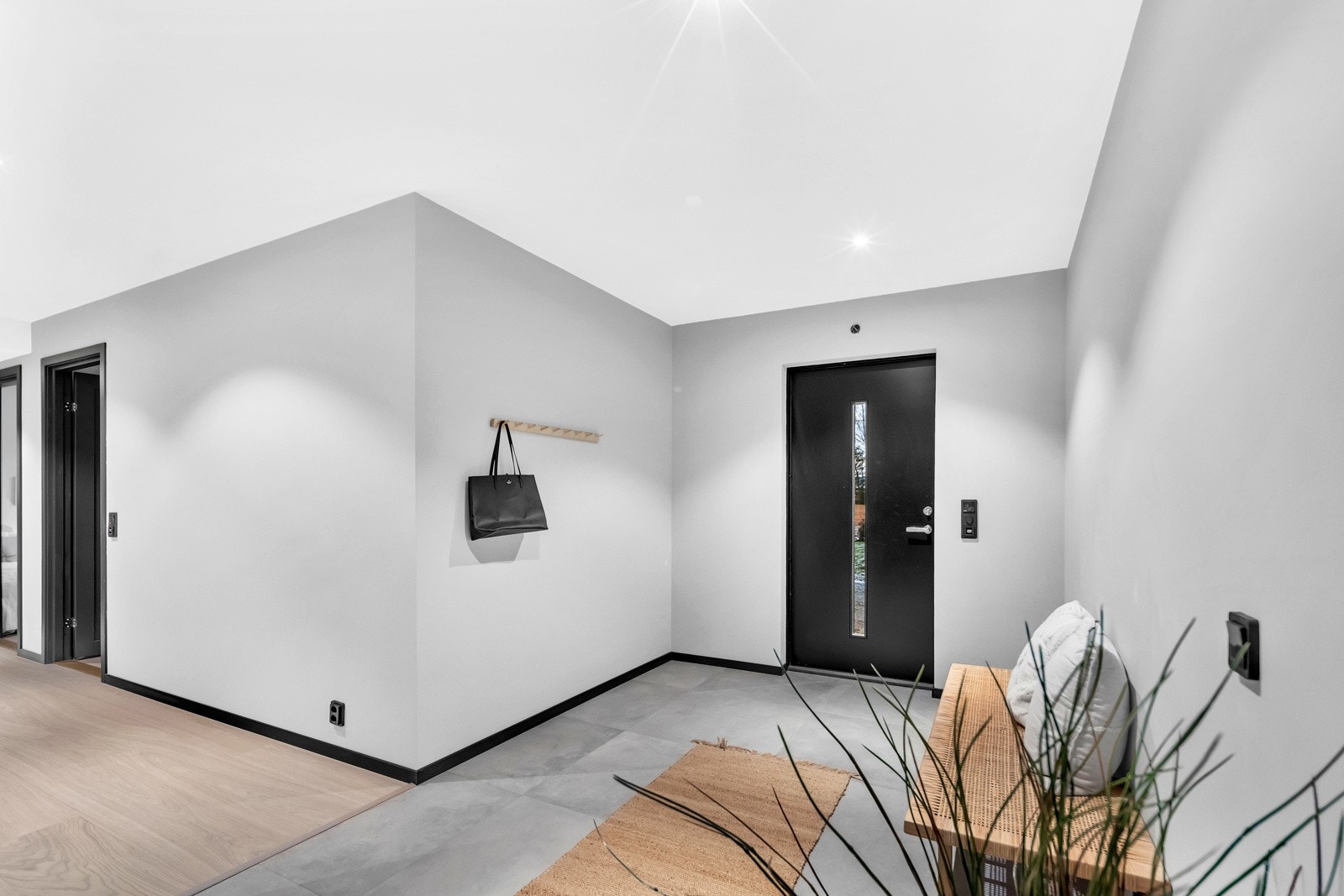 Innenfor hoveddøren blir man møtt med en romslig og meget innbydende entré med gråmalte veggflater, downlights og store, grå gulvfliser med varme. Galleribilde