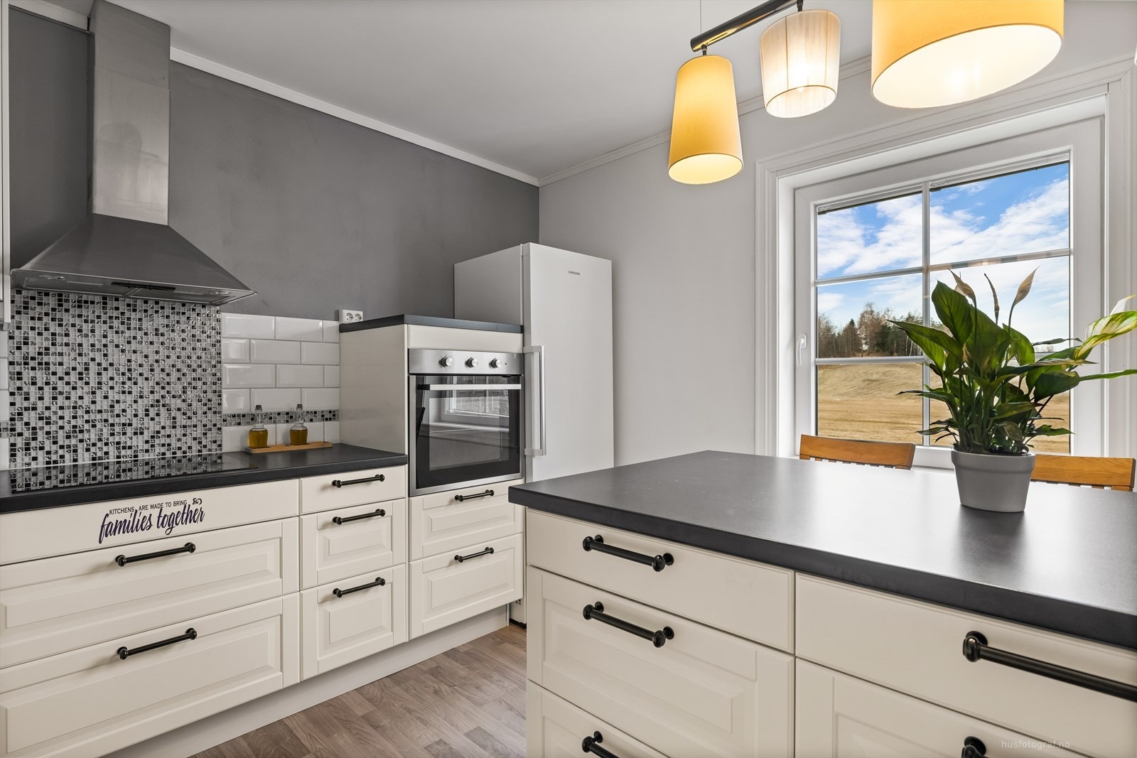 Pen hvit kjøkkeninnredning med profilerte fronter. Integrert oppvaskmaskin, komfyr og platetopp. Galleribilde