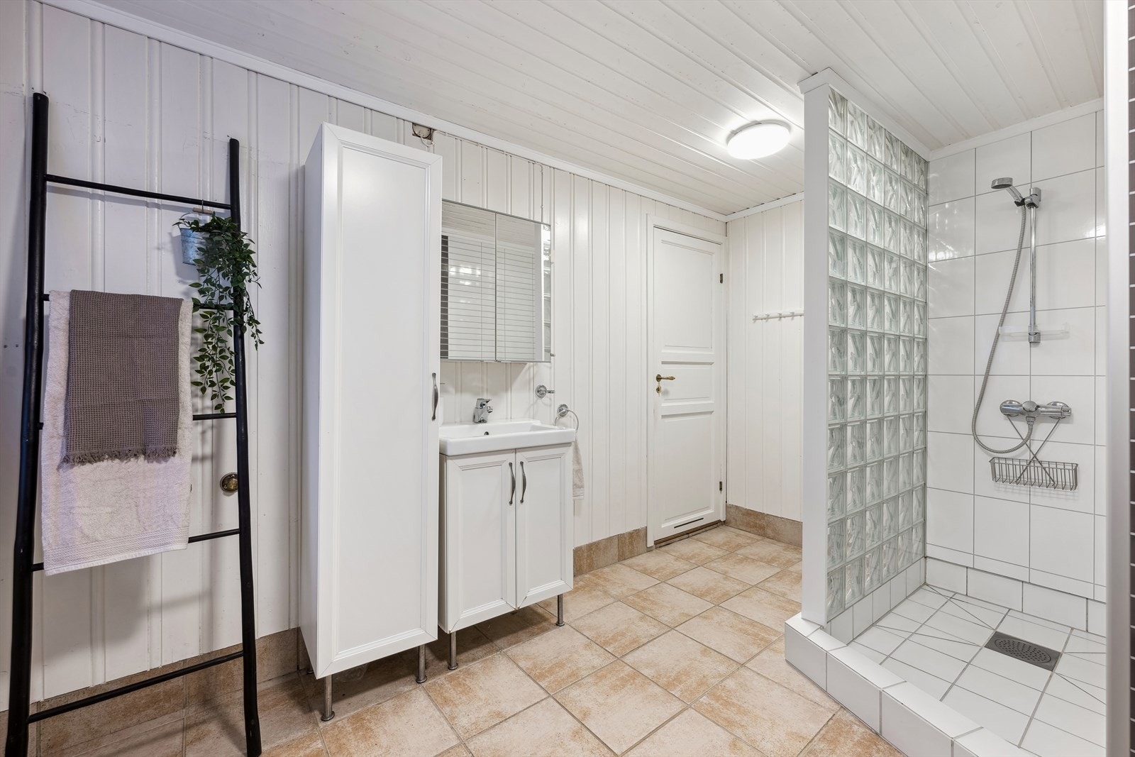 Pent bad med vegghengt wc, baderomsinnredning med vask og dusj med glassbyggerstein Galleribilde