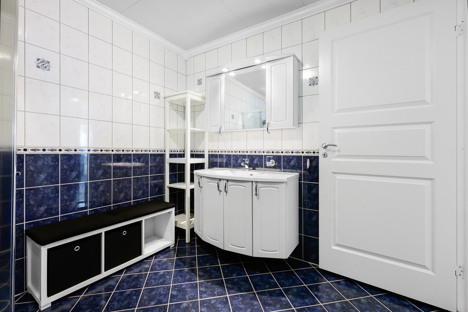 Helfliset bad med wc, dusjhjørne, baderomsmøblement med heldekkende servant. Overskap og underskap med god plass til oppbevaring. Galleribilde