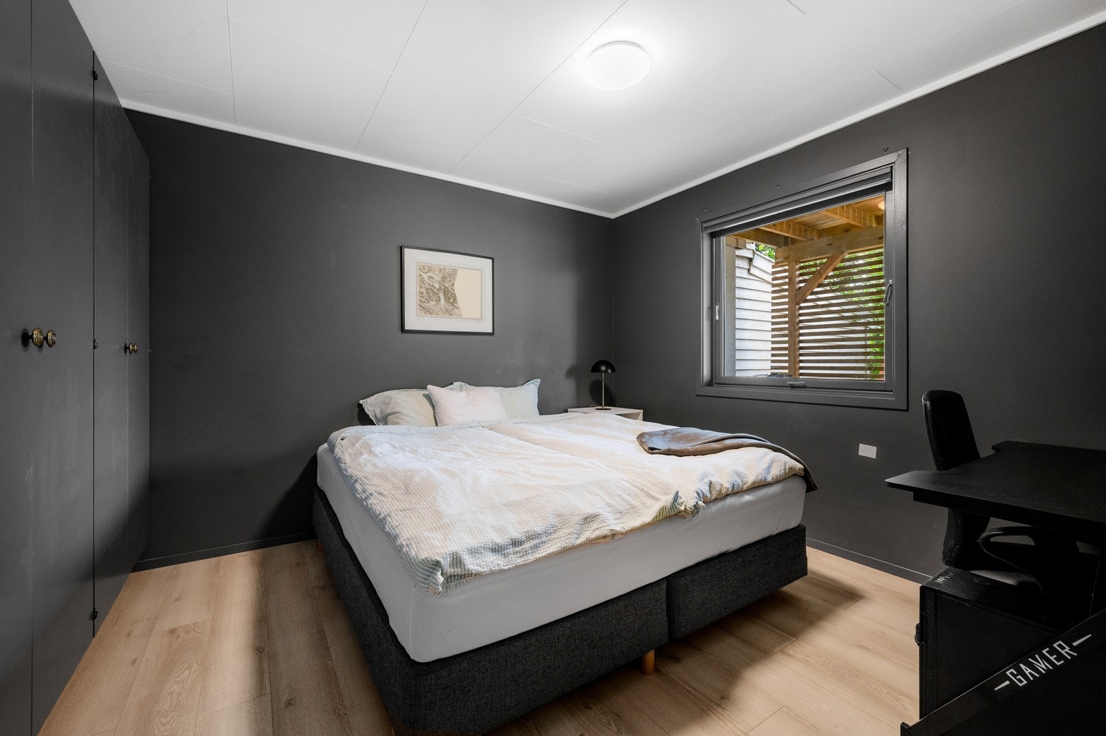 Soverom som har godt med plass til stor garderobe og dobbelt seng. Rommet er malt i fargen Bergknatt og gir en fin kontrast til tak og gulv. Galleribilde
