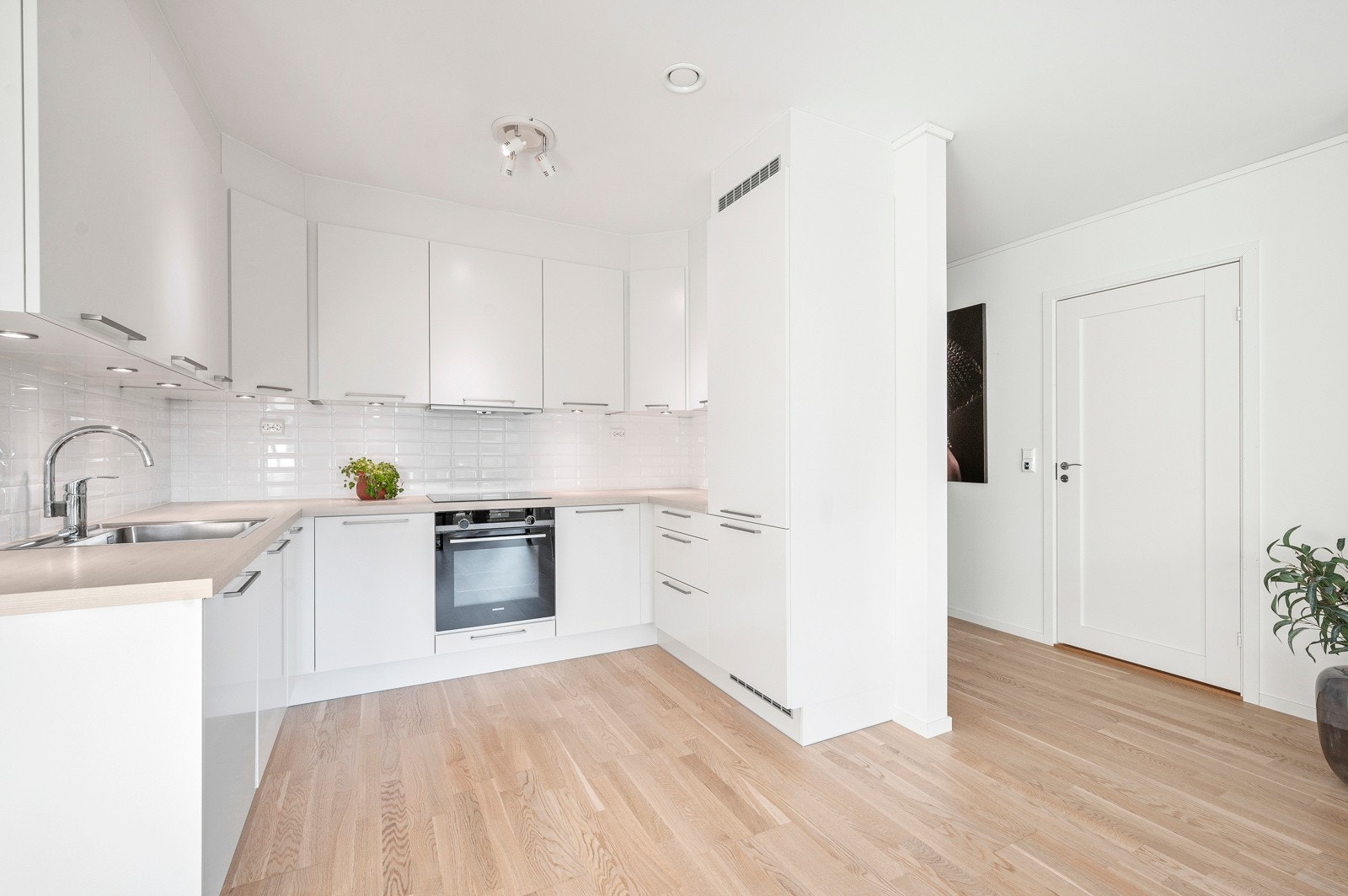 Klassisk og pent kjøkken som byr på godt med skap- og benkeplass. Innredning fra HTH i et tidløstfargevalg, laminat benkeplate og flislagt backsplash. Galleribilde