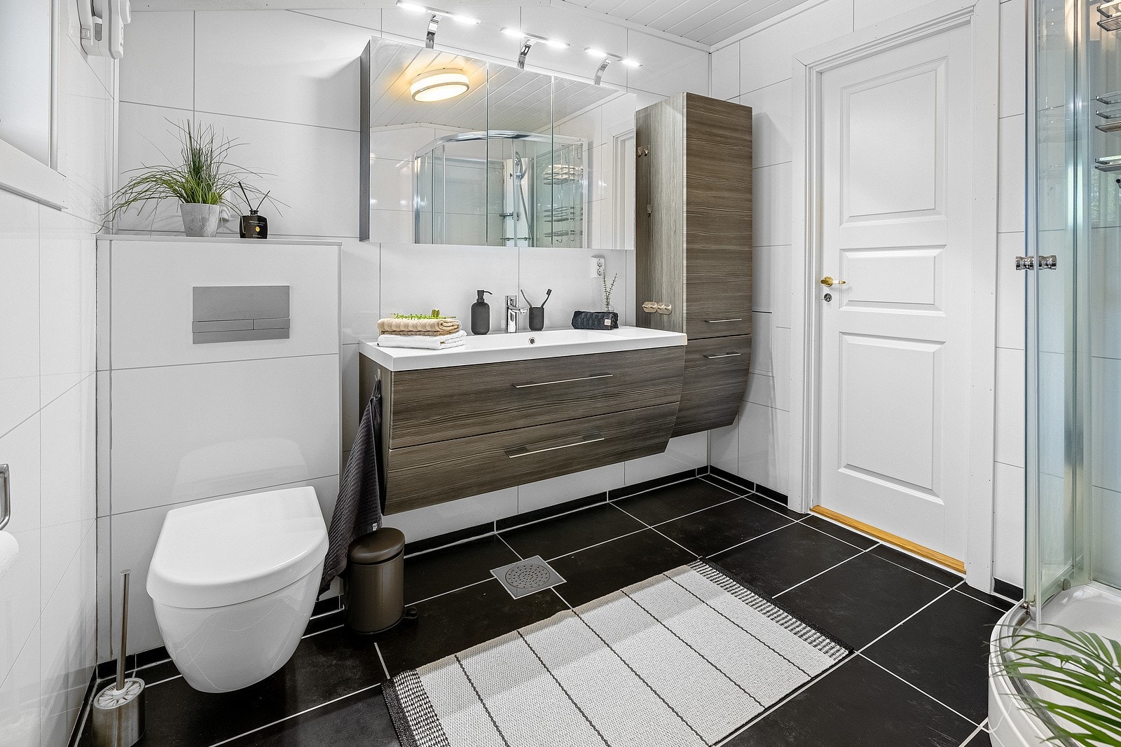 Baderommet varmes opp av elektriske varmekabler i gulvet og man har en moderne innredning med god oppbevaringsplass. Galleribilde