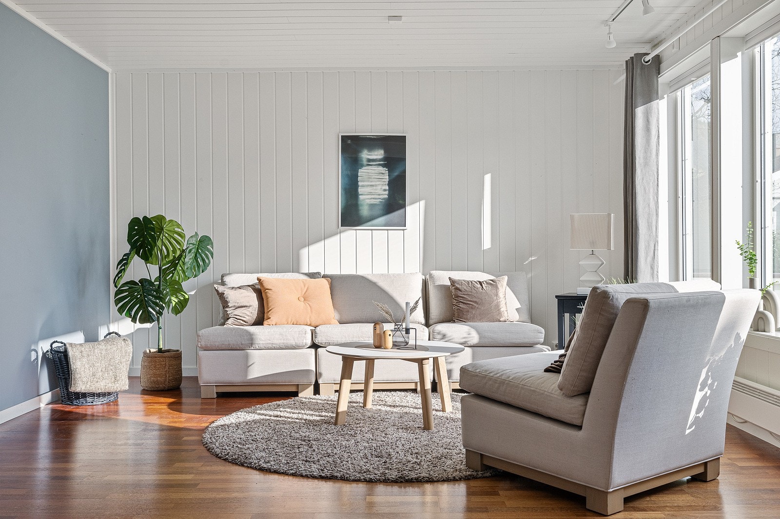 Lun stue som slipper inn mye naturlig lys og har plass til flere sittegrupper. Se hvor flott lyset treffer boligen. Galleribilde