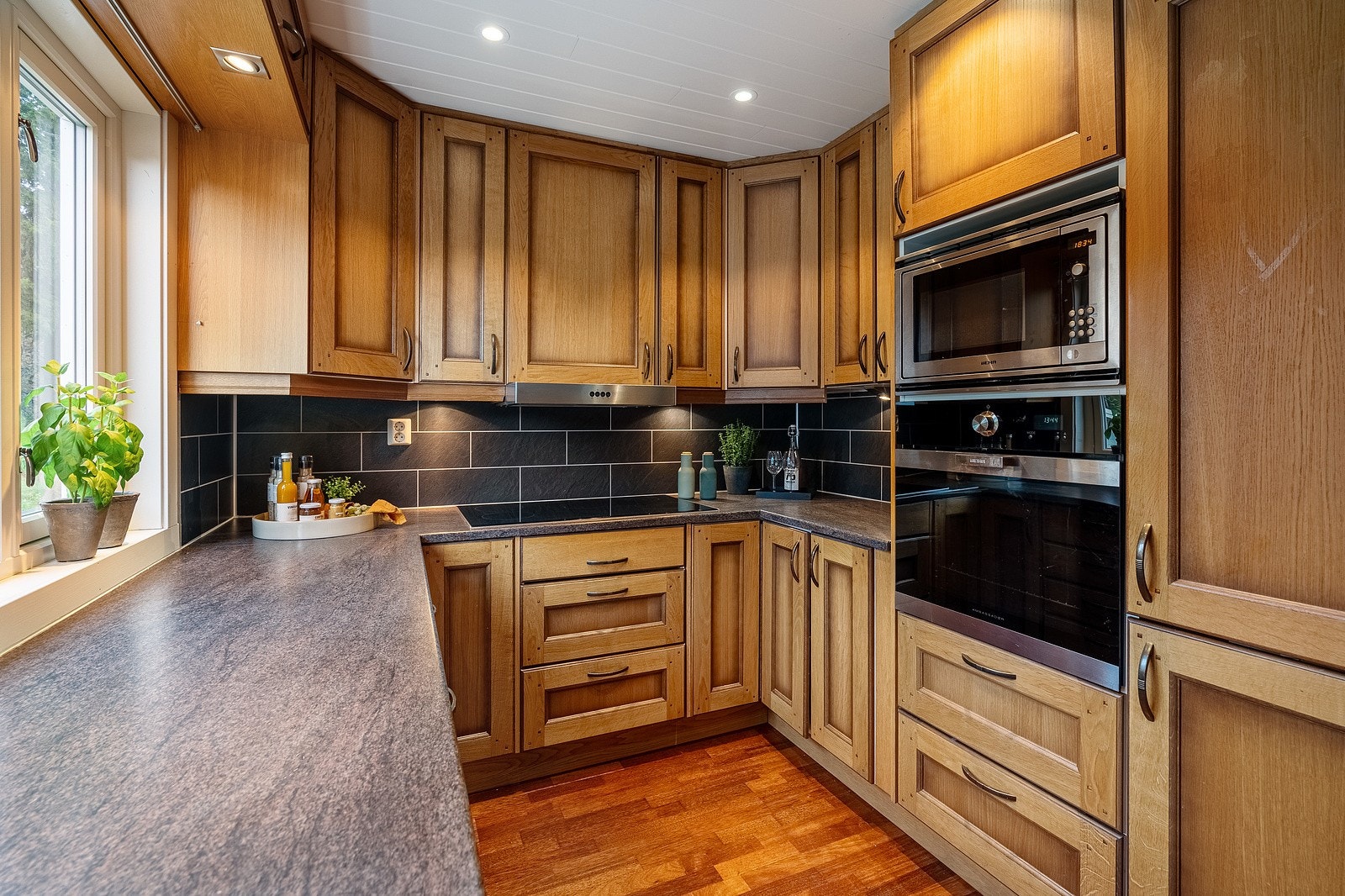 Klassisk kjøkken i landlig stil med rikelig med skap og benkeplass. Galleribilde