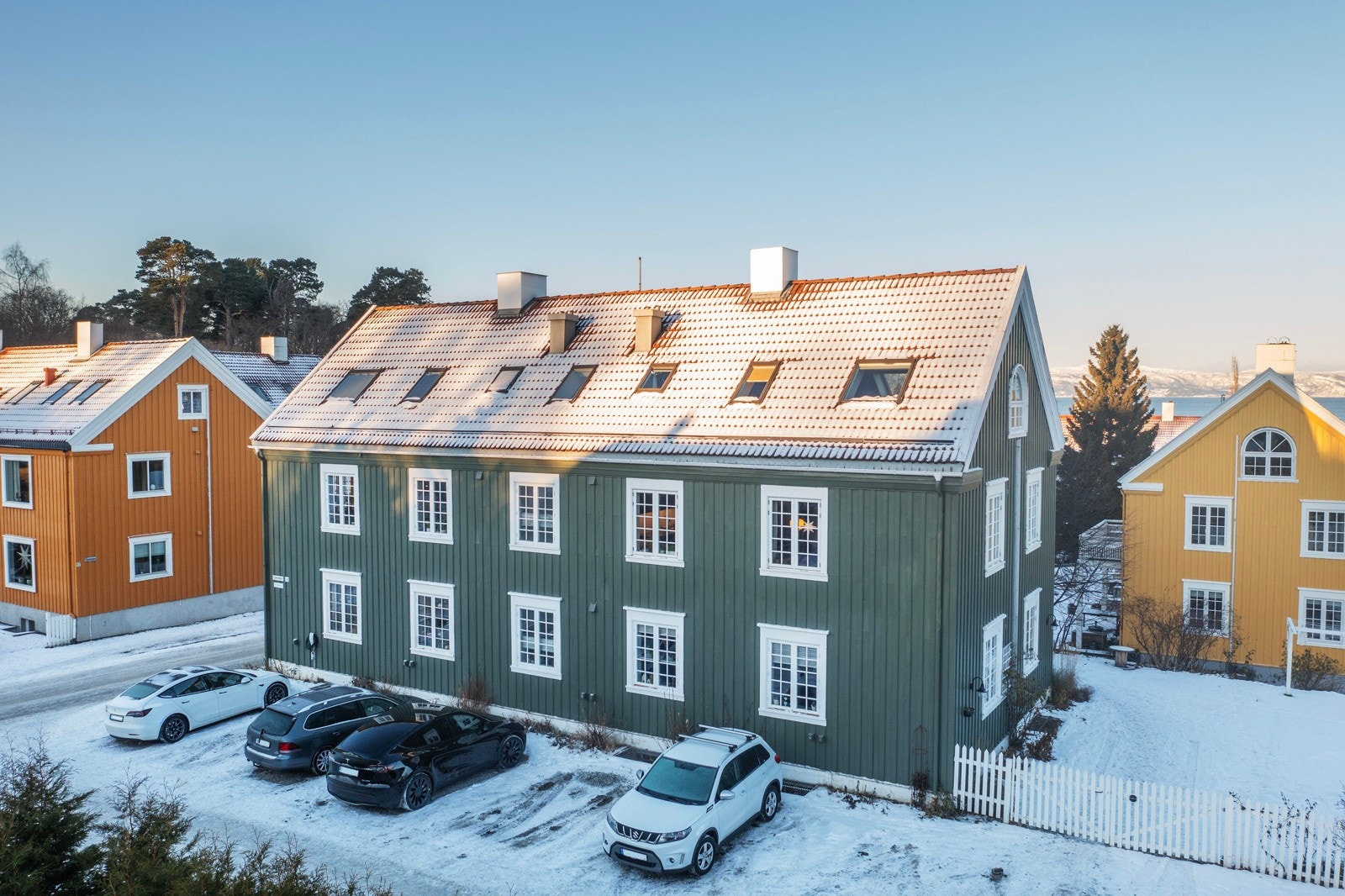 Dronefoto fasade, sameiets parkeringsplasser. Leiligheten har en egen merket plass. Galleribilde