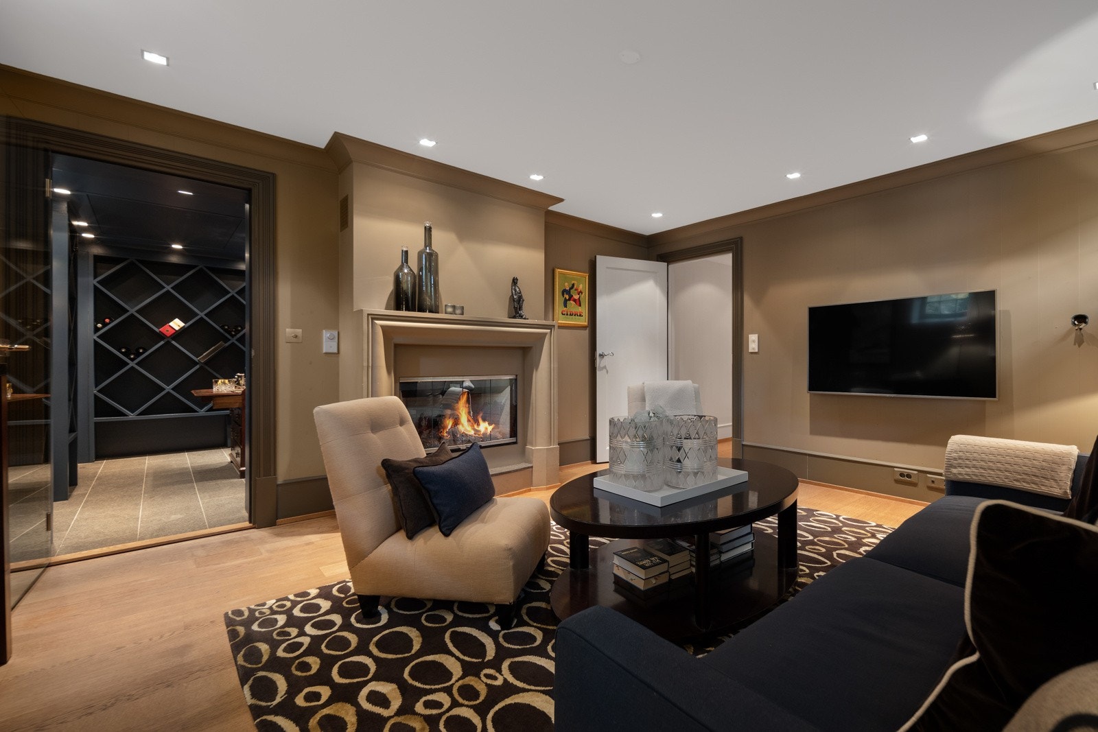 Tv-stue/kjellerstue med gasspeis og inngang til vinrom Galleribilde