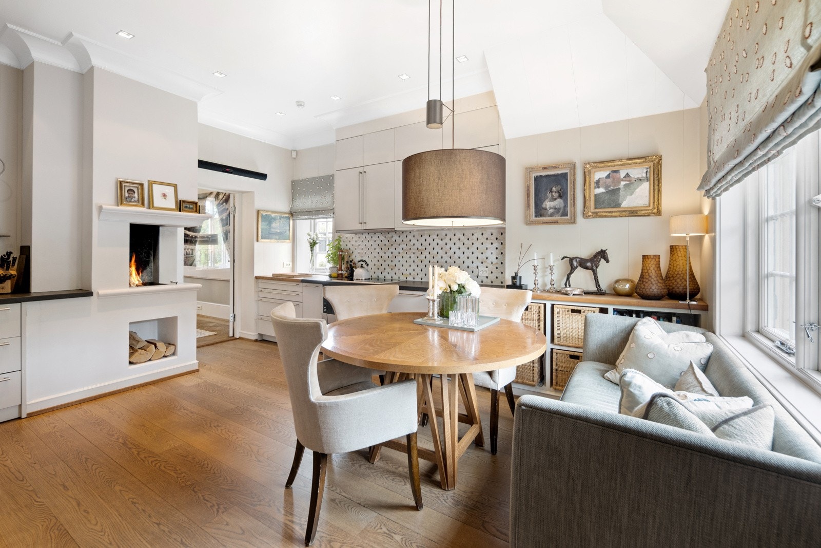 Lyst og moderne kjøkken med peis og hyggelig spiseplass. Galleribilde