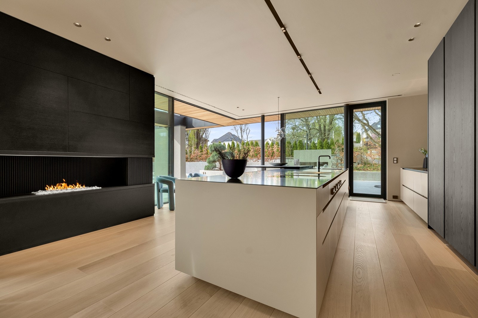 Høye skap fra gulv til tak med mørke, finerfronter og en eksklusiv øy med alle tenkelige finesser. Galleribilde