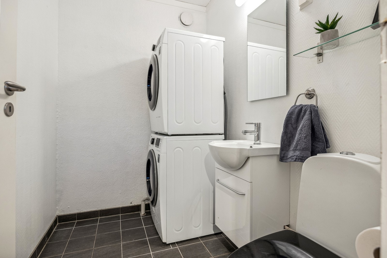 Pent vaskerom med fliser på gulv med behagelig varme. Rommet er videre utstyrt med toalett samt opplegg for vaskemaskin og tørketrommel. Galleribilde