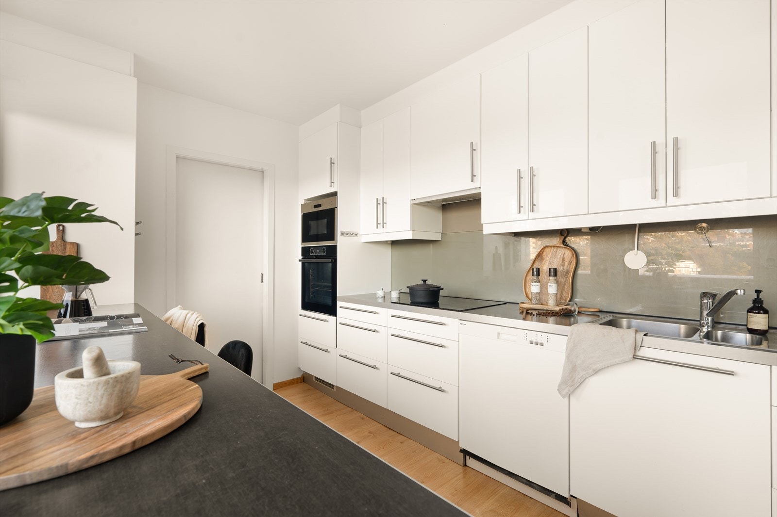 Kjøkkenet har glatte fronter og benkeplate av laminat. Det er kjøl/fryseskap, oppvaskmaskin og komfyr Galleribilde
