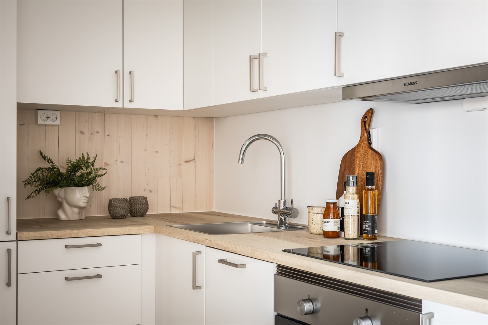 Tidløst og moderne kjøkken fra HTH med glatte fronter i hvit utførelse. Galleribilde