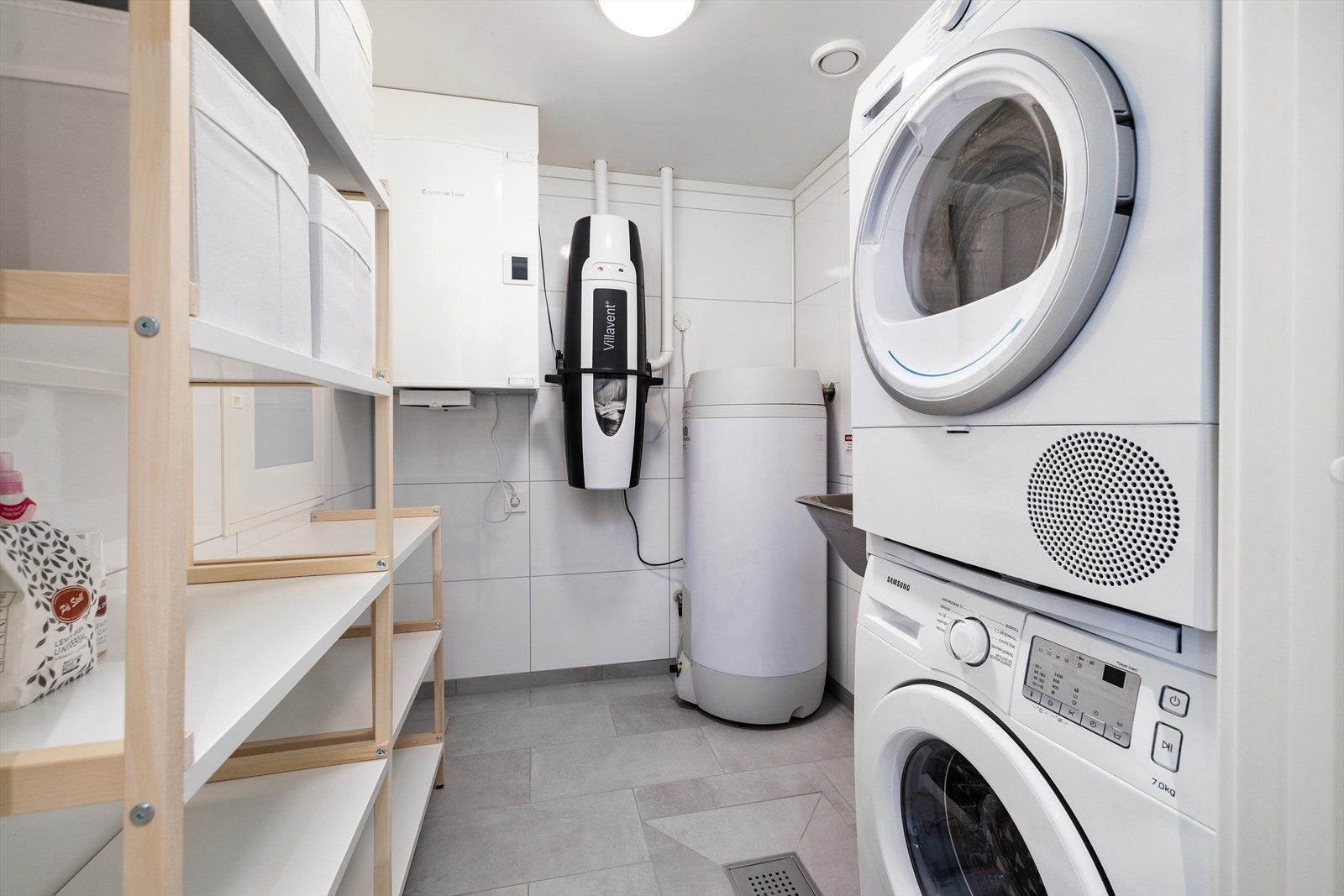 Vaskerom / teknisk rom med hyllestystem, sentralstøvsuger, ventilasjonsanlegg, varmtvannsberedet, vask og opplegg for vaskemaskin og tørketrommel. Galleribilde