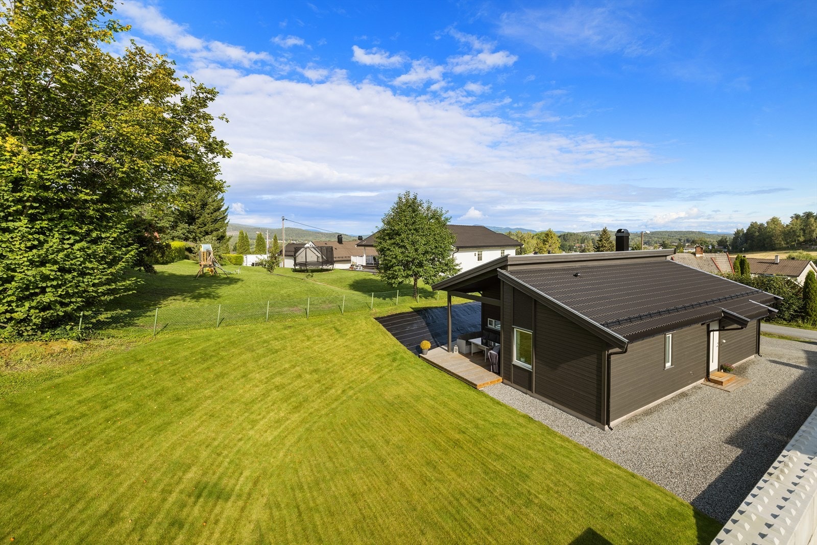Tomten er opparbeidet med gressplen og påbegynt blomsterbed. Galleribilde