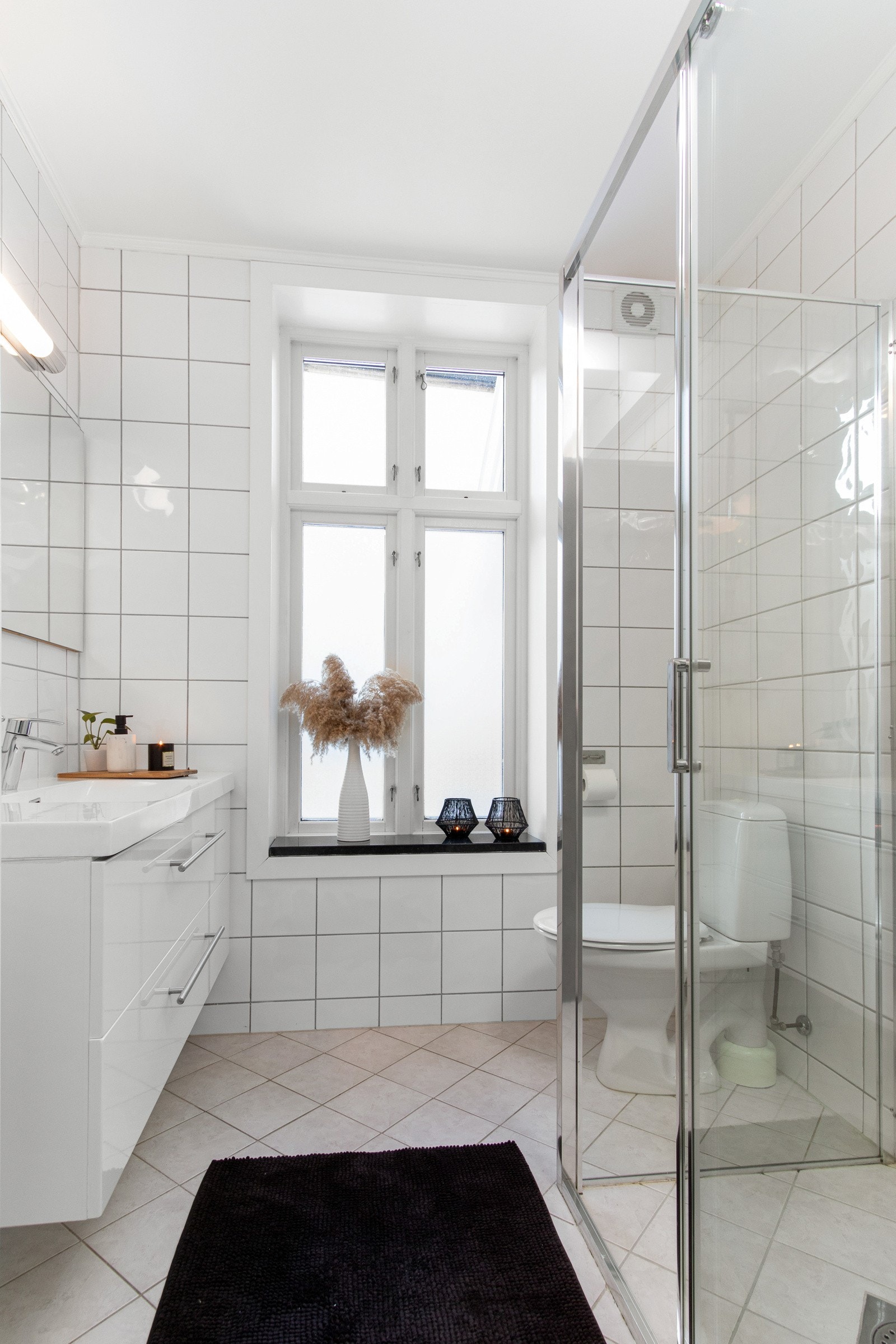 Her er det hvite veggfliser og lysegrå gulvfliser med varme. Galleribilde