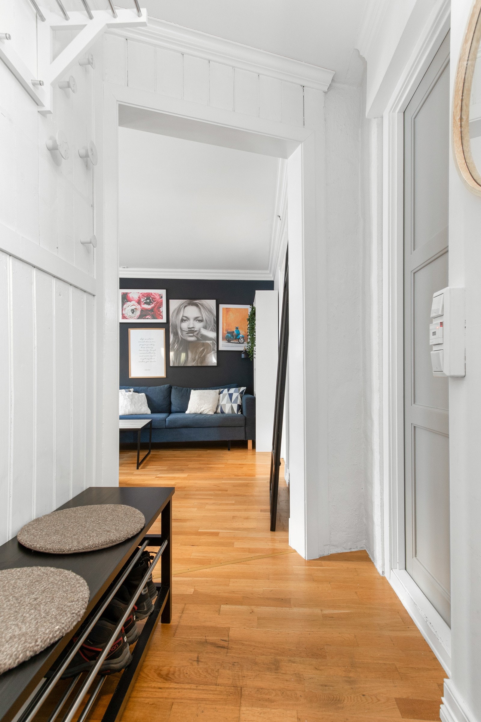Inne møtes man av en entré i direkte tilknytning til stuen, med samme type parkett på gulvet. Veggene er kledd med hvitmalt panel, og det passer fint å innrede med knagger og skohyller i entreen. Galleribilde