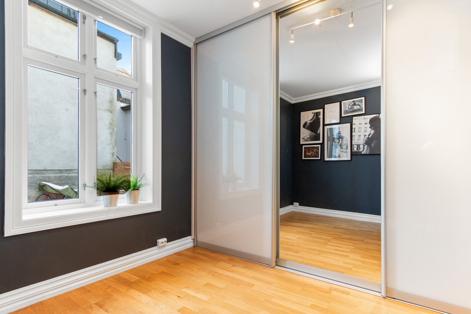 Rommet har et plassbygd skap med tilhørende kontorpult i egen nisje, og langs den ene veggen er det montert en stor, plassbygget skyvedørsgarderobe med dels speilfronter. Galleribilde