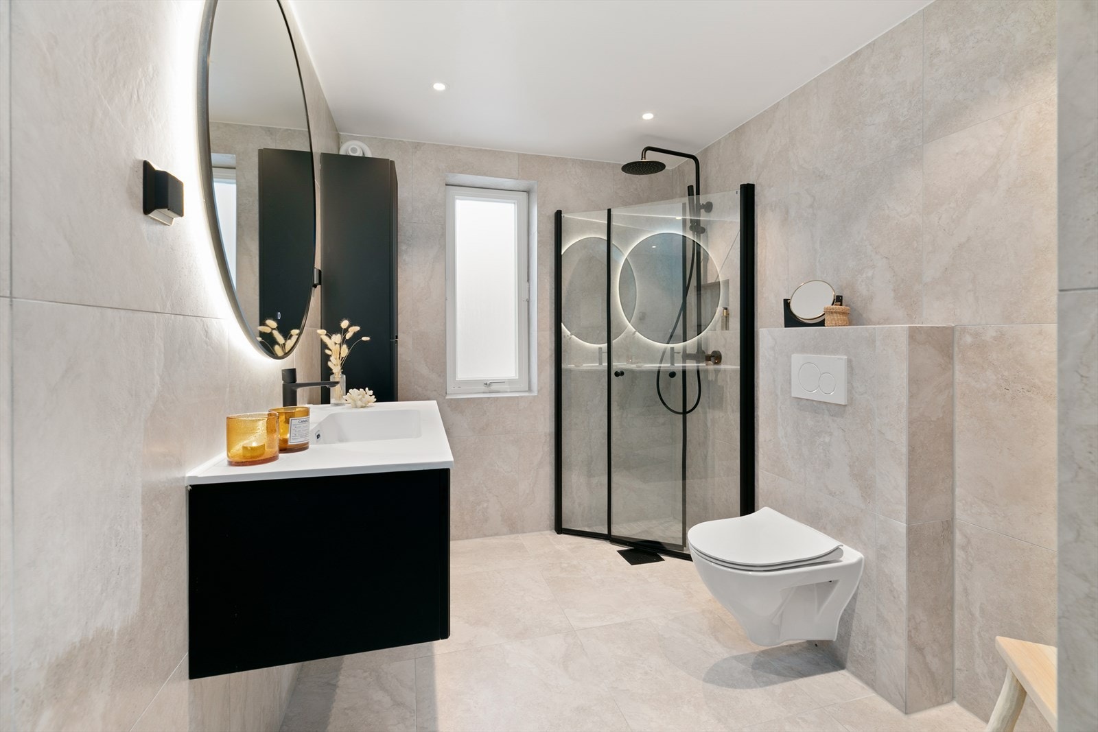 Lekkert flislagt bad fra 2023. Her er det vegghengt klosett, dusjhjørne, servant med underskap. Speil over servant med belysning. Opplegg for vaskemaskin og tørketrommel Galleribilde