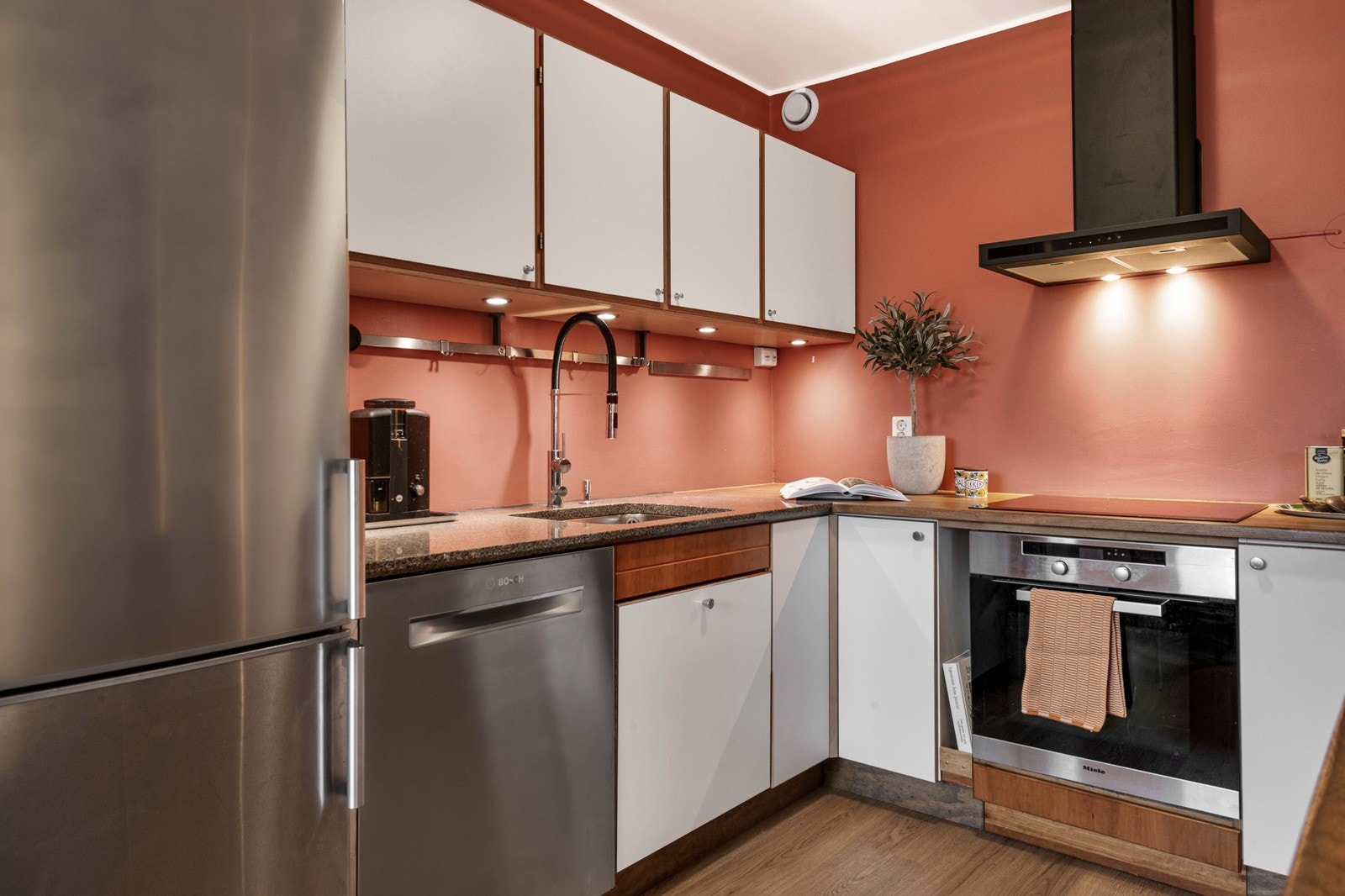 Benkeplater er av stein og heltre. Blandebatteri med fleksibel slange og dusjfunksjon. Downlights undre overskapene gir gode arbeidsforhold. Galleribilde