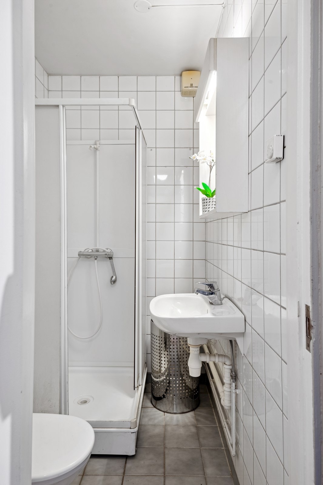 Badet er av ukjent årstall, og inneholder baderomsinnredning med servant, gulvmontert toalett og dusjkabinett. Galleribilde